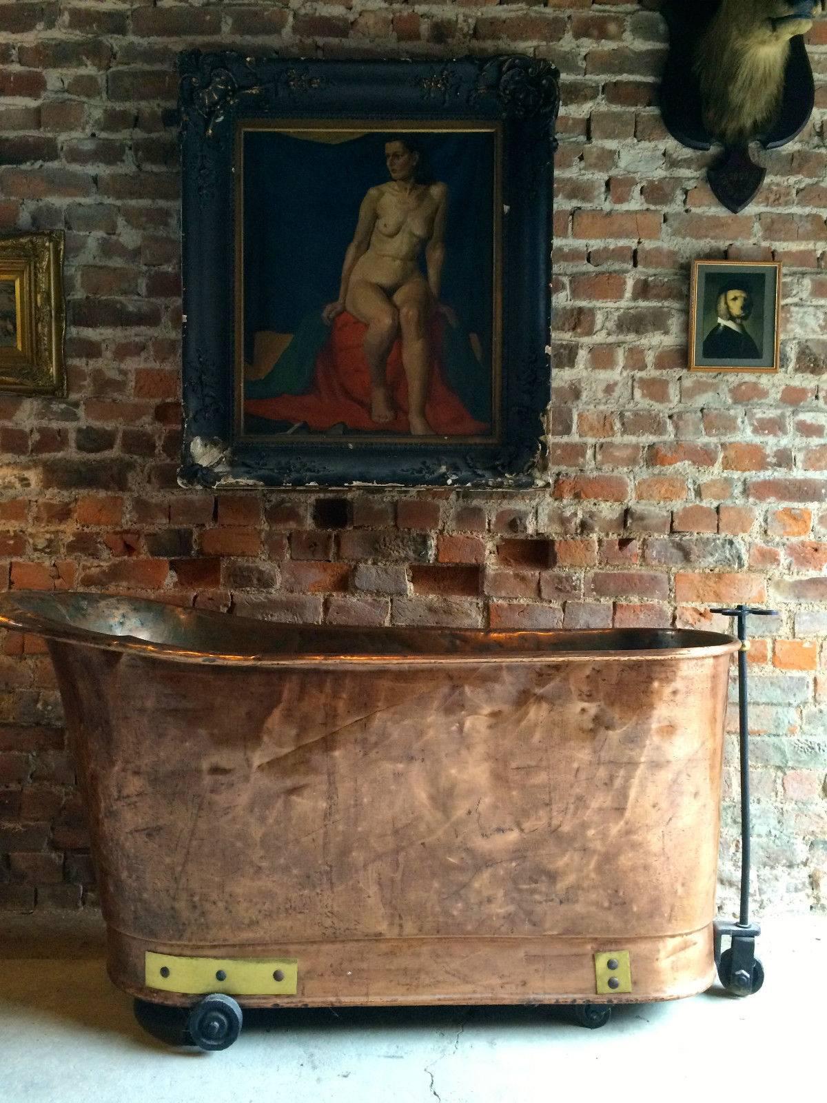 A beautiful antique 19th century Victorian French decorative galvanized copper bath, bound with brass rivets, wrought iron steering frame and sitting on casters, the bath would adorn any room as a functional bath or simply as a piece of cool art