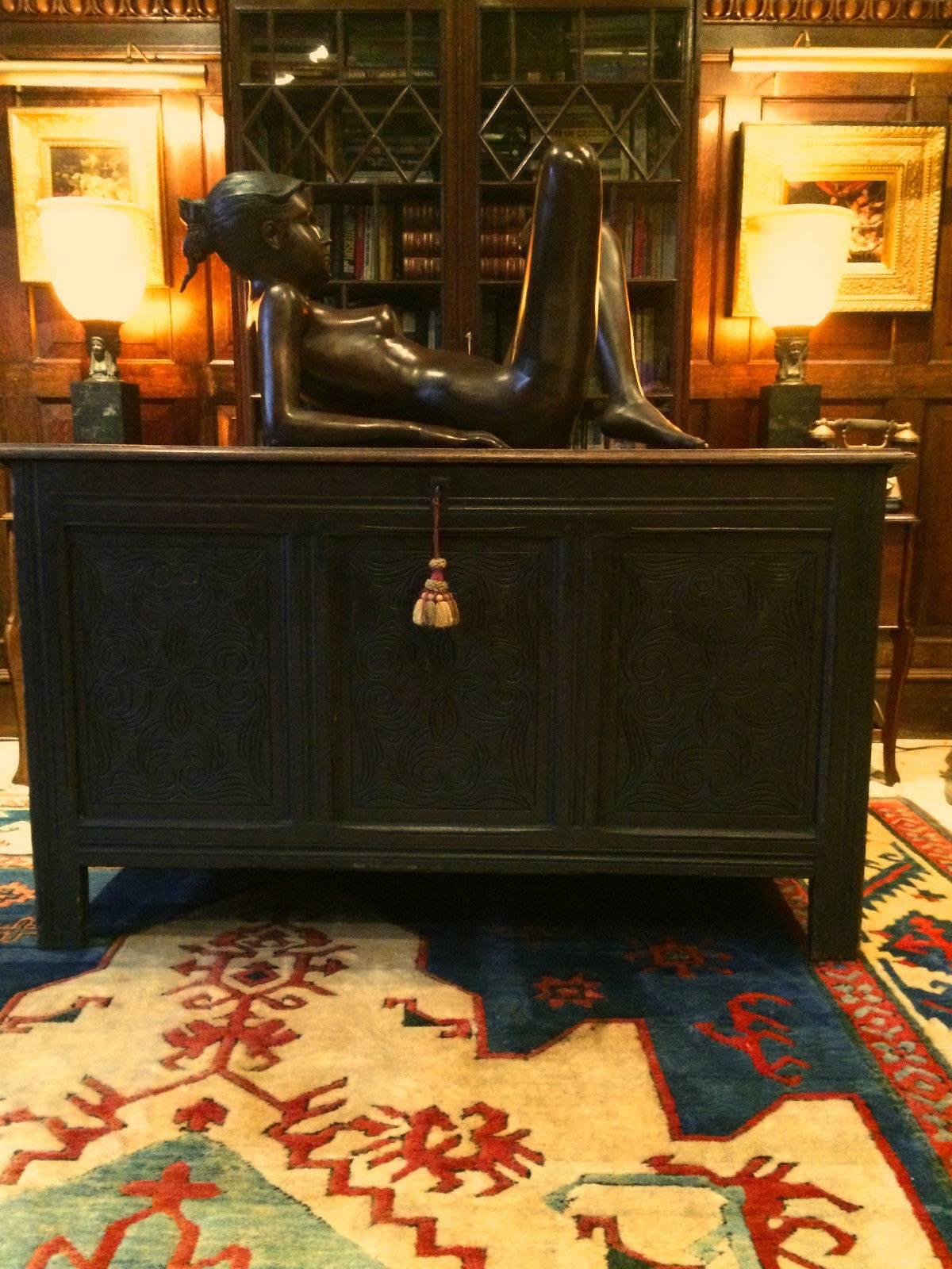 A 19th century large carved country oak coffer chest or blanket box, the rectangular hinged top with opening to storage inside with geometric decoration, amongst scrolls and raised on stile supports, comes with key and tassel, believed to belong