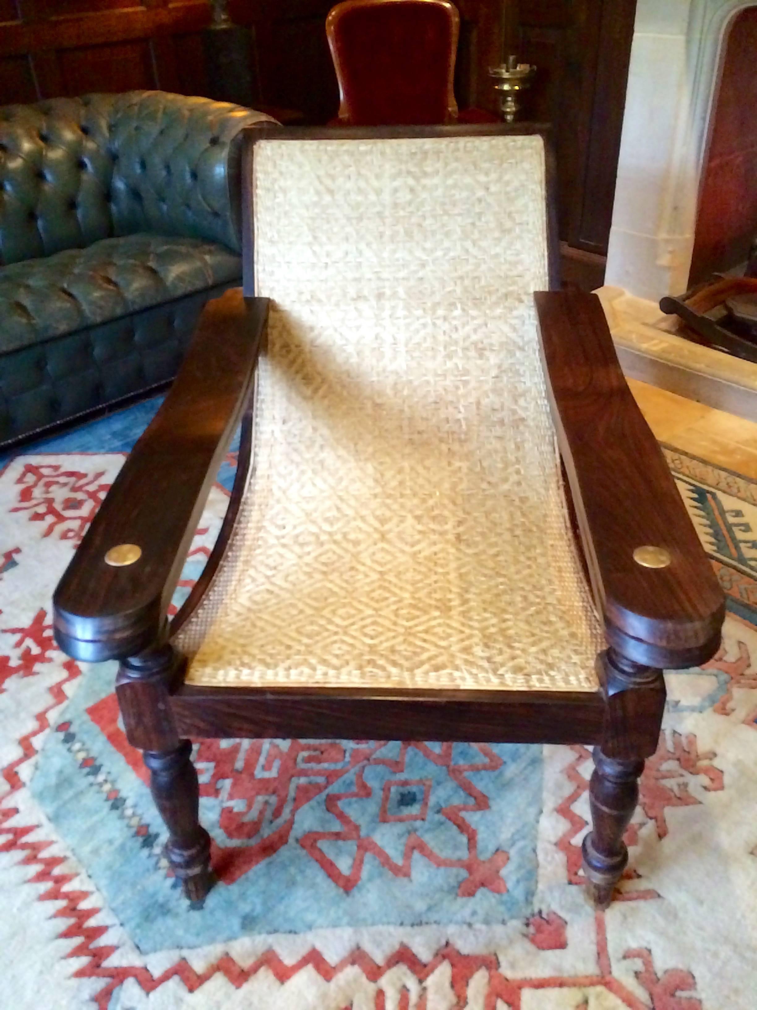 A contoured antique ‘Planters’ plantation chair with permanently extending arm/leg rests, caning to seat in a geometrical basket weave and in pristine condition, sumptuous reclining lines, sitting on gorgeous arched back legs with turned font legs,
