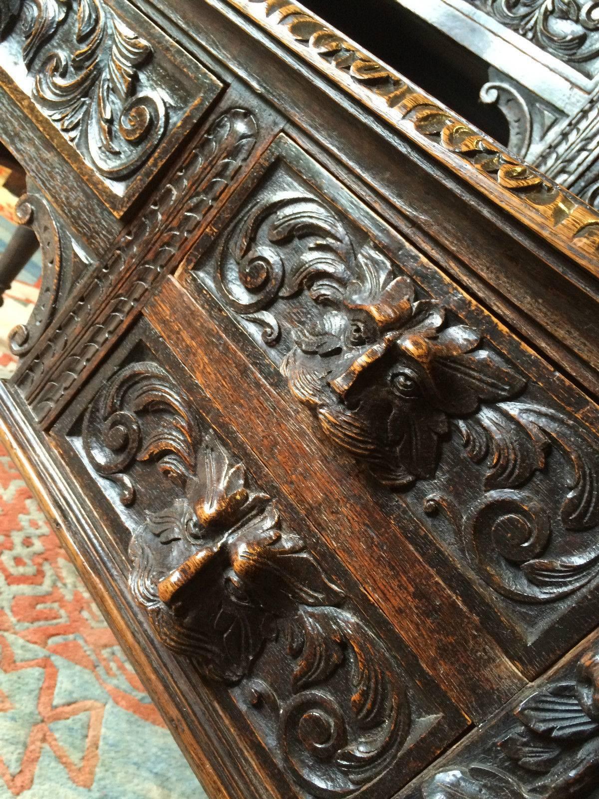 Antique 19th century Victorian profusely carved dark oak 'Green Man' writing table desk, the raised back with carved pediment, fitted five drawers, each with mask head handles, inset leather writing surface, the kneehole base fitted with five