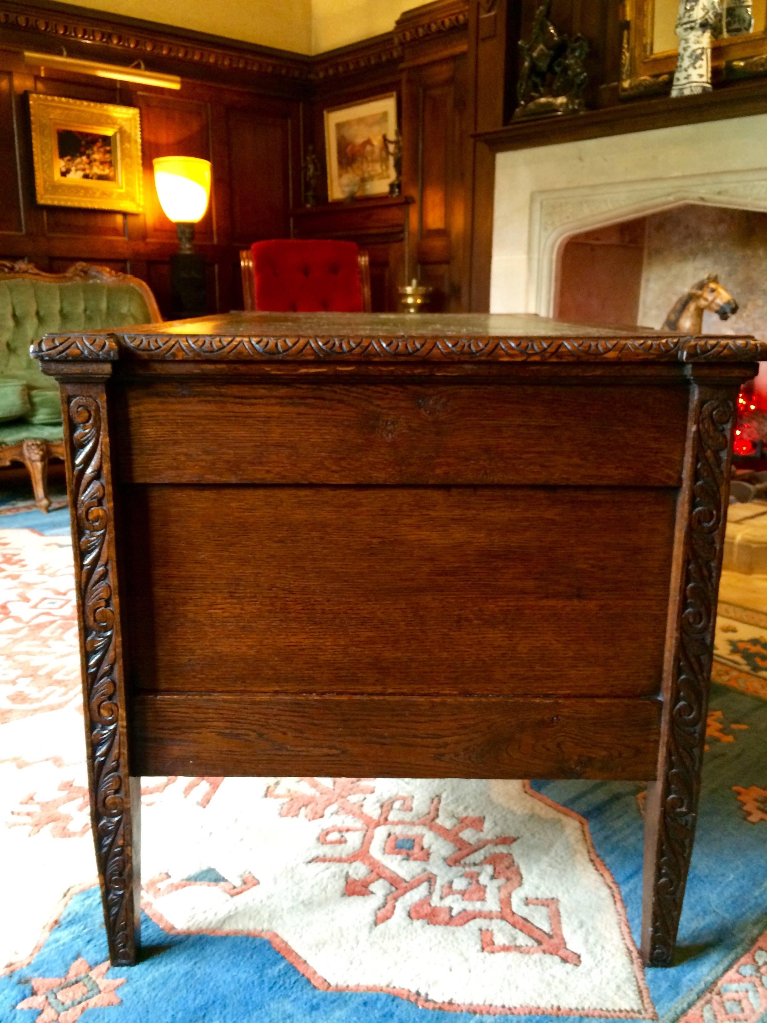 A excellent quality and real centre piece for any room, 19th century Victorian carved oak kneehole writing desk of rectangular form, rectangular top with tooled leather inset, fitted with an arrangement of seven frieze drawers with carved green man,