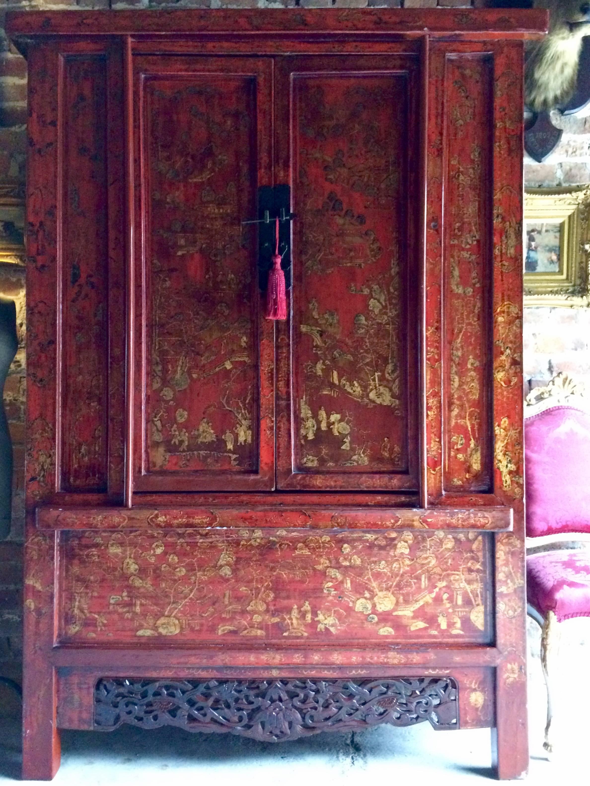 A stunning antique 19th century elm Chinese lacquered chinoiserie two door wardrobe armoire, circa 1899 from the Shanxi region of China, decorated in red lacquer and gilt featuring pagoda's village scenes, rivers, boats, flowers and dragons, two
