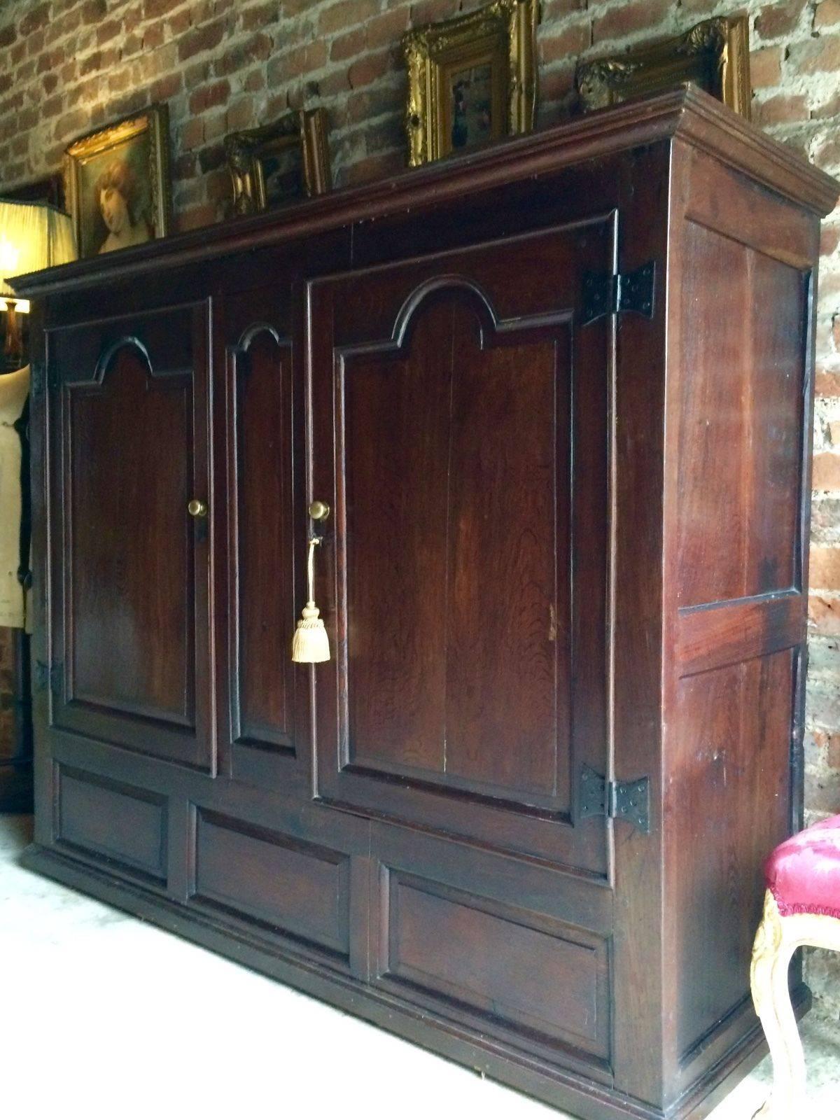 Antique 18th century solid oak two door livery cupboard wardrobe, corniced top over a pair of twin fielded arch topped panelled doors with exposed hinges, comes with one non working key and tassel, the interior is a blank space to either add shelves