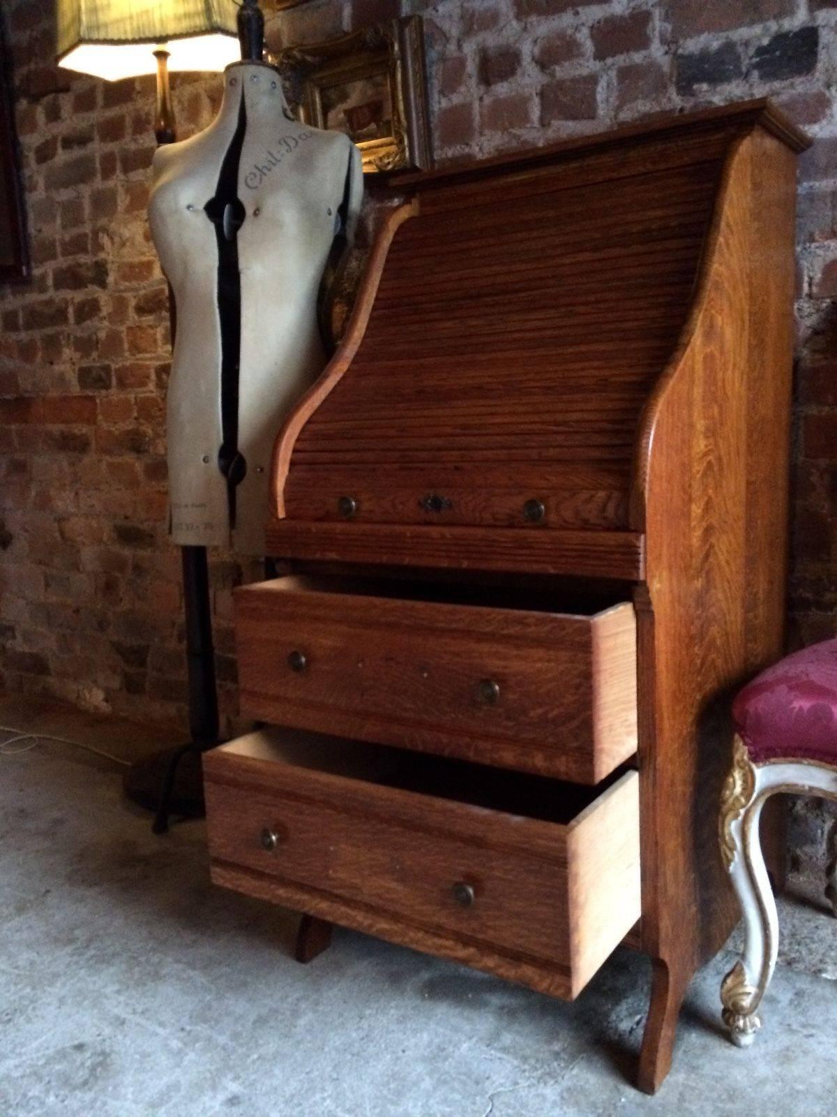 A fabulous and very unusual early 20th century slim vintage Industrial golden oak roll top bureau or desk, the tambour front enclosing a fitted interior over two short drawers, pull-out slide worktop area and raised on bracket feet, ideal