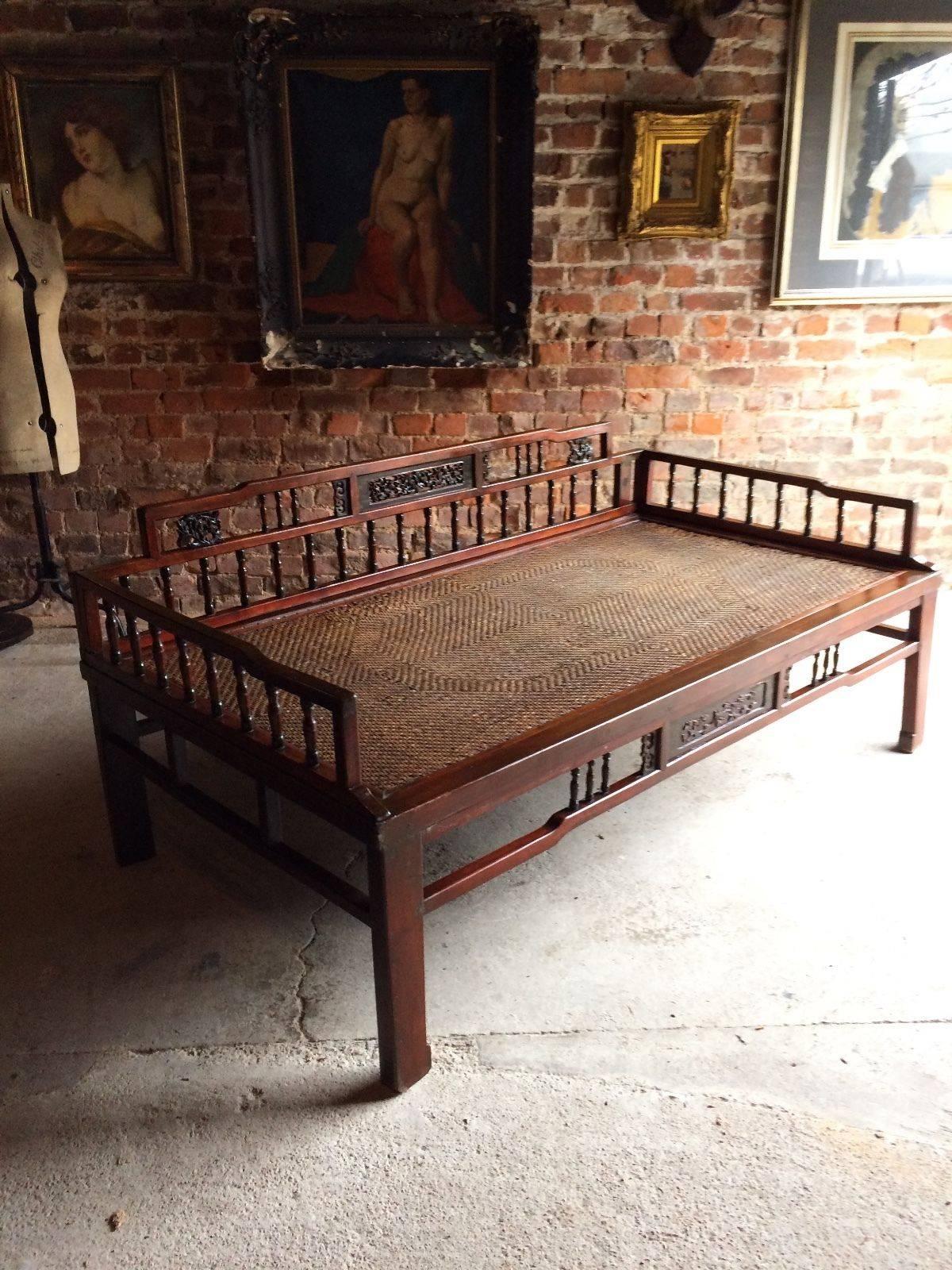 A beautiful antique Victorian 19th century large Chinese Asiatic hardwood daybed - opium sofa, The back with panels showing birds and blossoming trees, with rounded edges, raised on square legs with a rattan weave and panelled seat.
