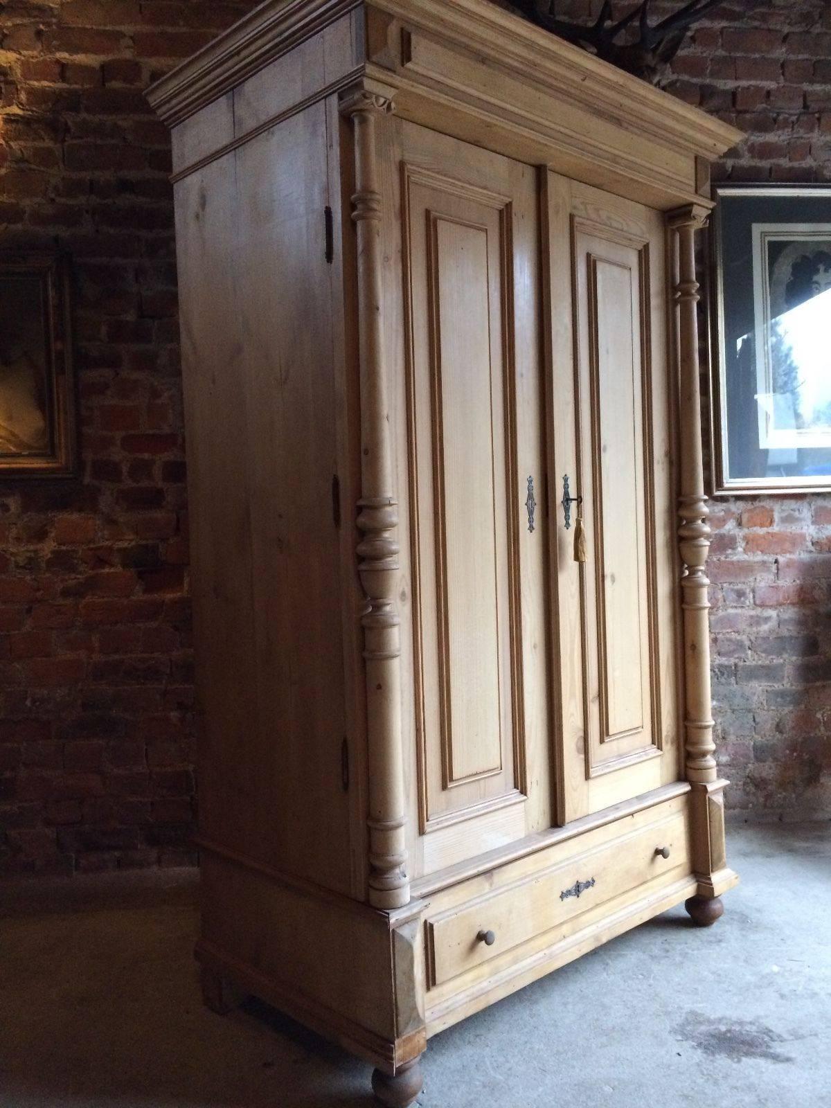 A fabulous large and imposing 19th century French solid pine double wardrobe armoire, circa 1890, large overhanging cornice above two large panelled doors with turned column pilasters either side, single brass hanging rail within, large single