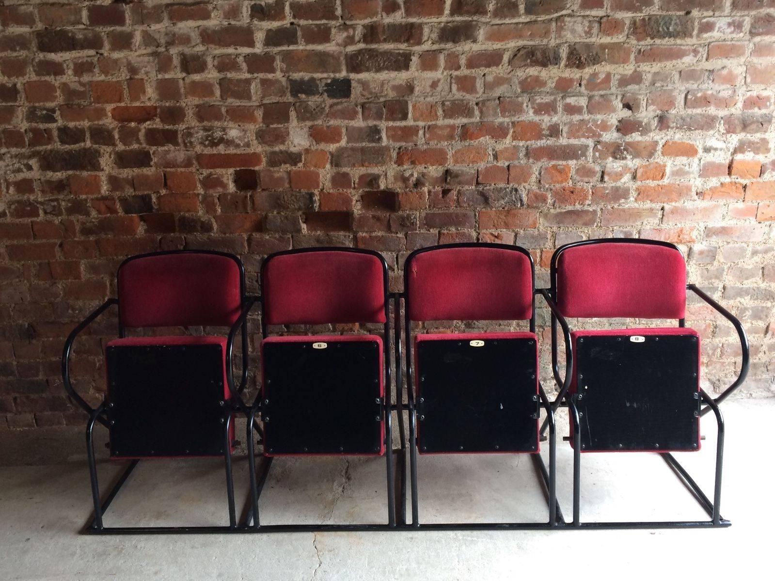 A super cool and utterly fabulous bank of four, run retro mid-20th century folding cinema chairs upholstered in red moquette fabric and set to a black metal mounted frame, extremely comfortable and portable with no need to be bolted to floor.