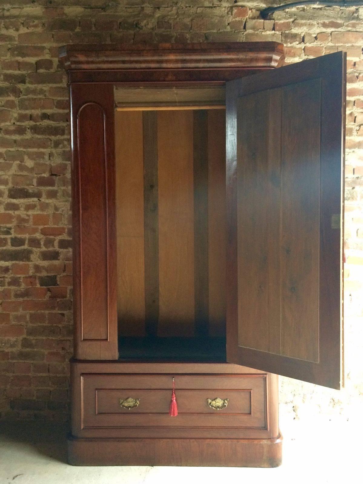 A beautiful Victorian walnut mirror fronted single wardrobe armoire, circa 1870, removable cornice top over a single mirror fronted panelled door with hanging rail inside, above single drawer and raised on plinth base, comes with two working keys