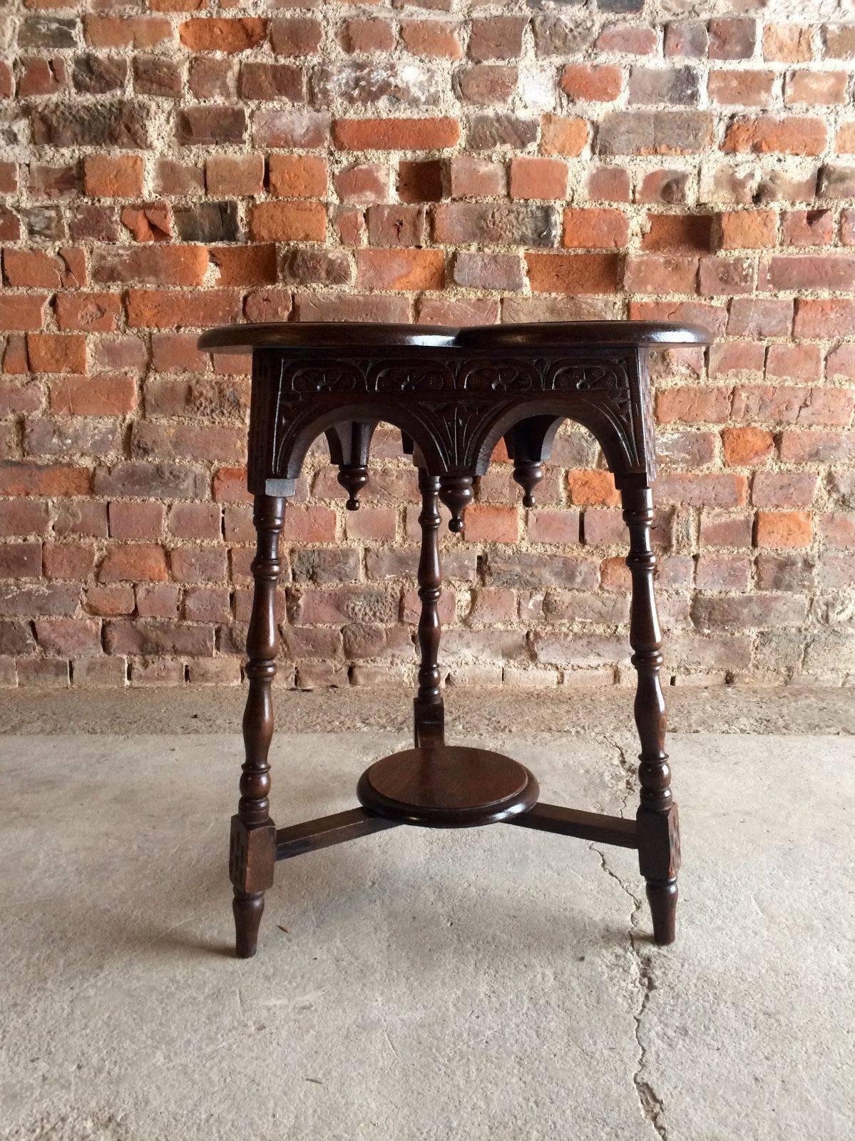 A stunning solid oak Victorian 19th century heavily carved three leg trefoil table, having parcel shelf and Gothic carvings of thistles and flowers, looks amazing.