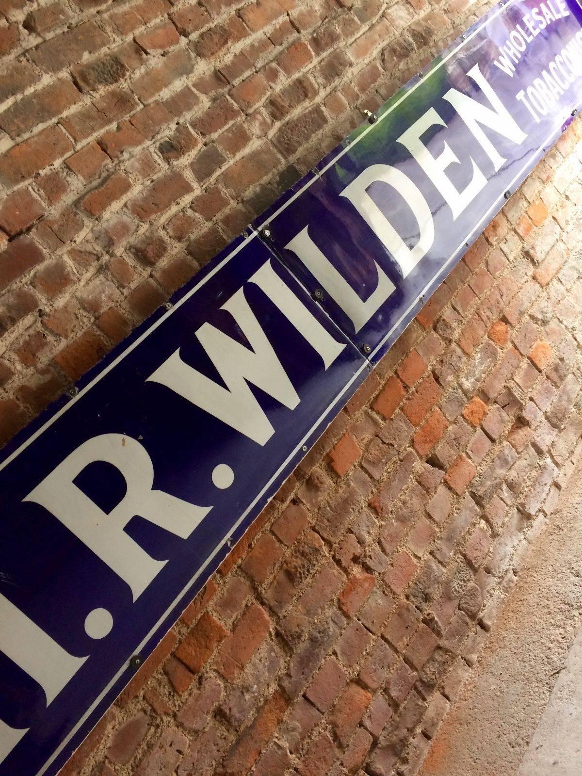 Fabulous extremely large antique enamel sign H.R. WILDEN TOBACCONIST ENAMEL SIGN. Large enamel in two sections (13ft 2ins), trade/ supplied/ H.R. Wilden/ wholesale/ tobacconist white lettering on dark blue background. Outer edge chips and rust.