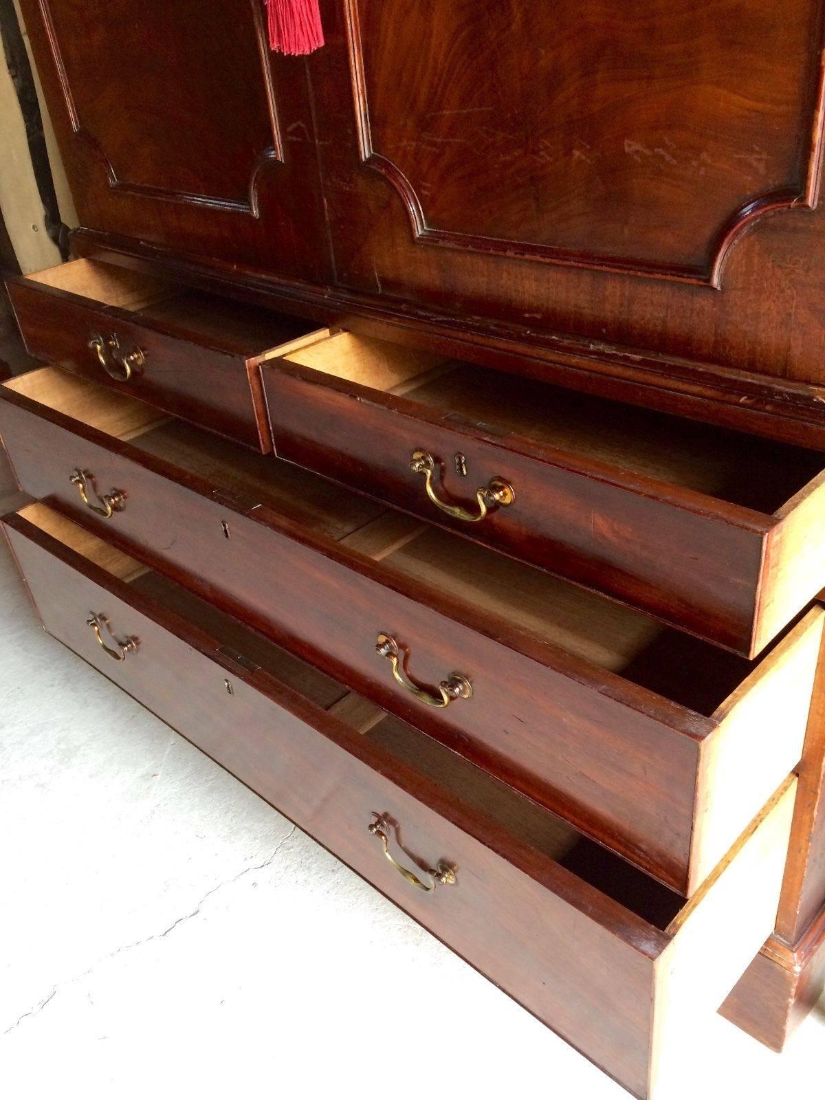 A Victorian mahogany dwarf linen press having a pair of panelled doors enclosing three oak slides, over two short over two long drawers, raised on shaped bracket feet.