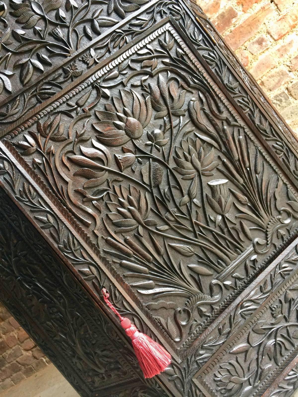 A beautiful antique early 19th century heavily carved stained mahogany single door hall or bathroom cupboard with profusely carved decoration of lotus flowers, grapes and vines, the piece comes with one working key with tassel, looks amazing.