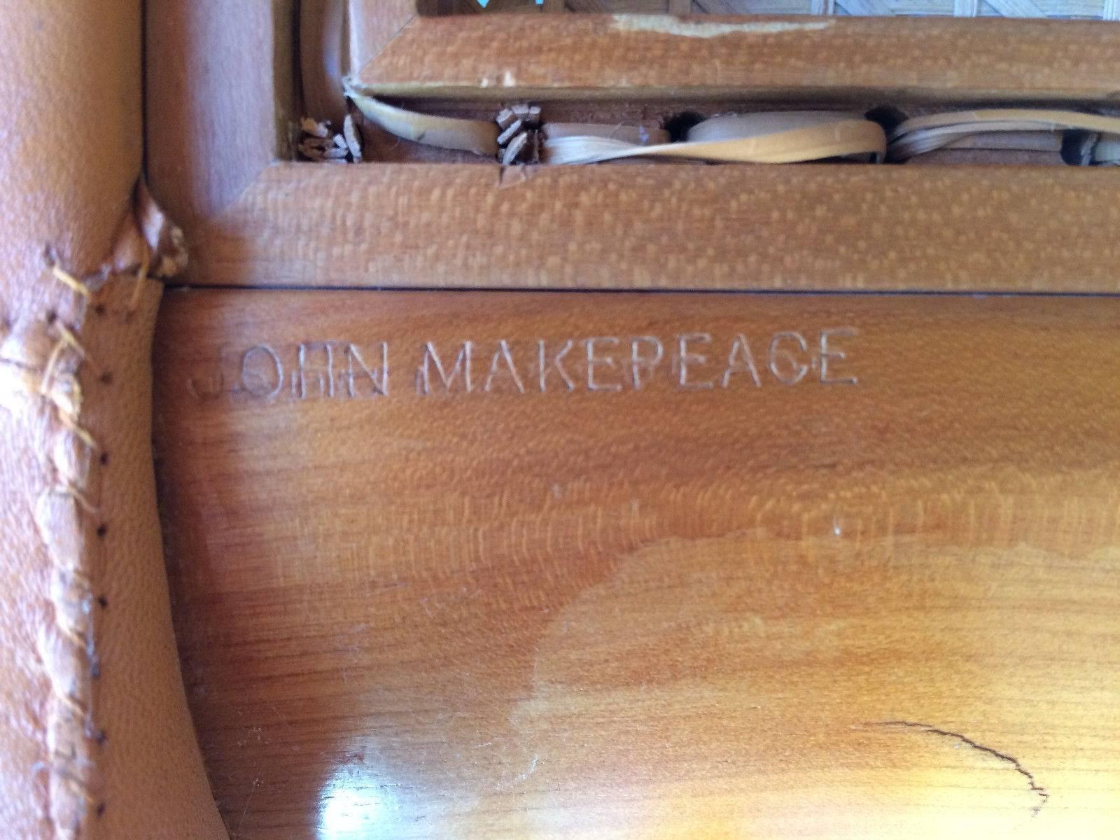 A very rare and unique John Makepeace (British, born 1939), tan leather covered armchair, circa 1970, the beech frame with inset cane panelled back and seat, raised curved arms and square legs, the frame stamped John Makepeace and bearing label for