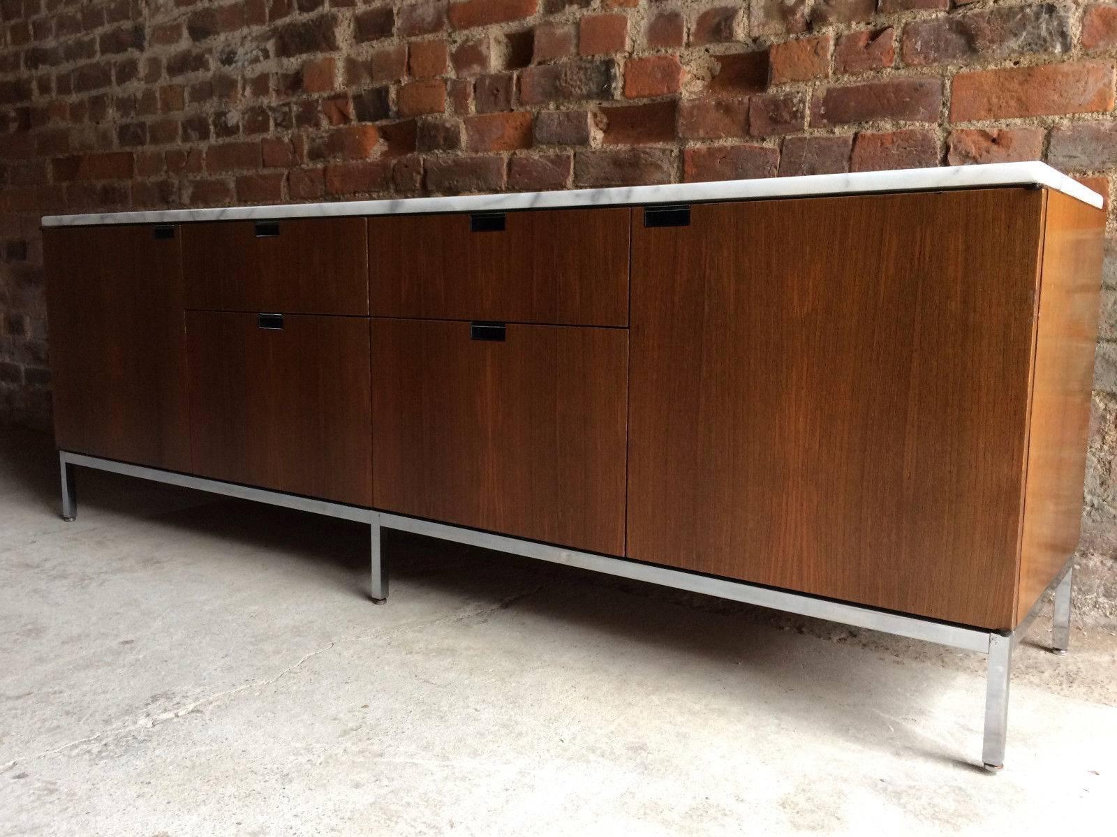 A stunningly beautiful iconic masterpiece by Florence Knoll, this light walnut credenza, rectangular white marble top with soft grey veining running throughout over the long symetrical base with two cupboards to the sides with a bank of four drawers