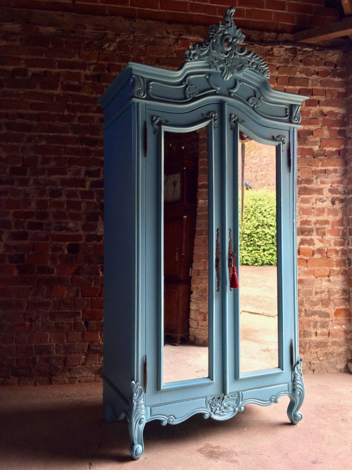 A gorgeous French painted double armoire wardrobe of tall proportions, the arched corniced pediment over twin mirror panelled doors, with hanging rail, over shelf with two single drawers below raised on short cabriole legs, comes with one working