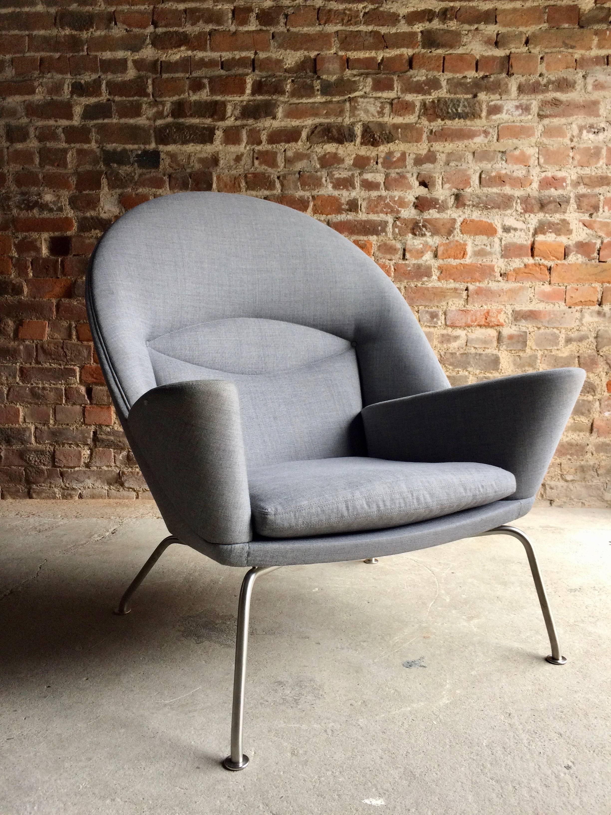 A model 468 oculus lounge chair, designed by Hans Wegner, manufactured by Carl Henson 2002, in light grey fabric, on satin steel legs, bearing makers label to underside.

A sought-after and sculptural armchair designed by Hans J. Wegner in the