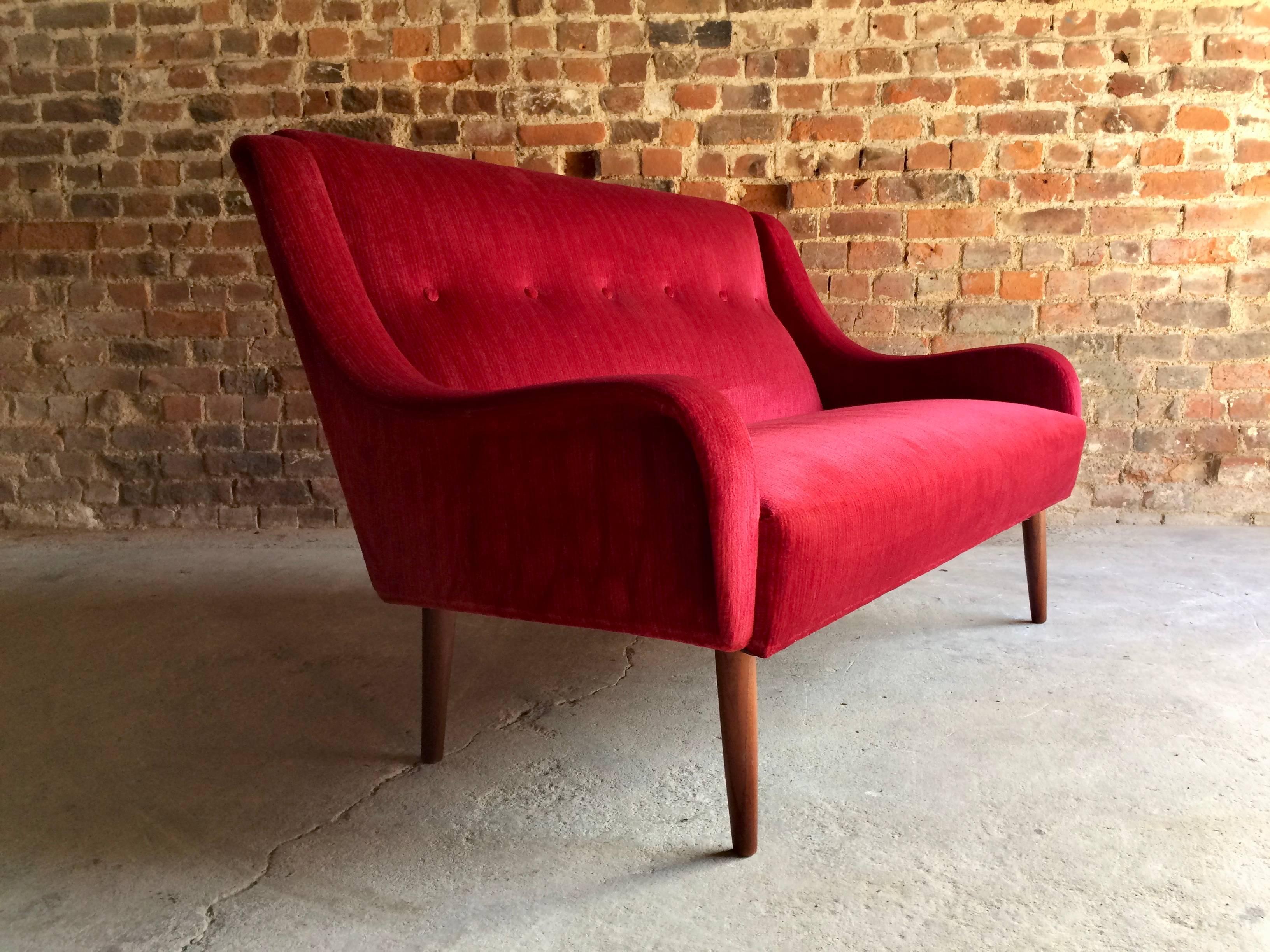 A beautifully stylish Mid-Century Danish design red velour-type two-seat sofa on teak tapering legs circa 1950s, legs with some minor marks and wear, some very minor discolouration in places, no rips or tears, all buttons present, overall a very