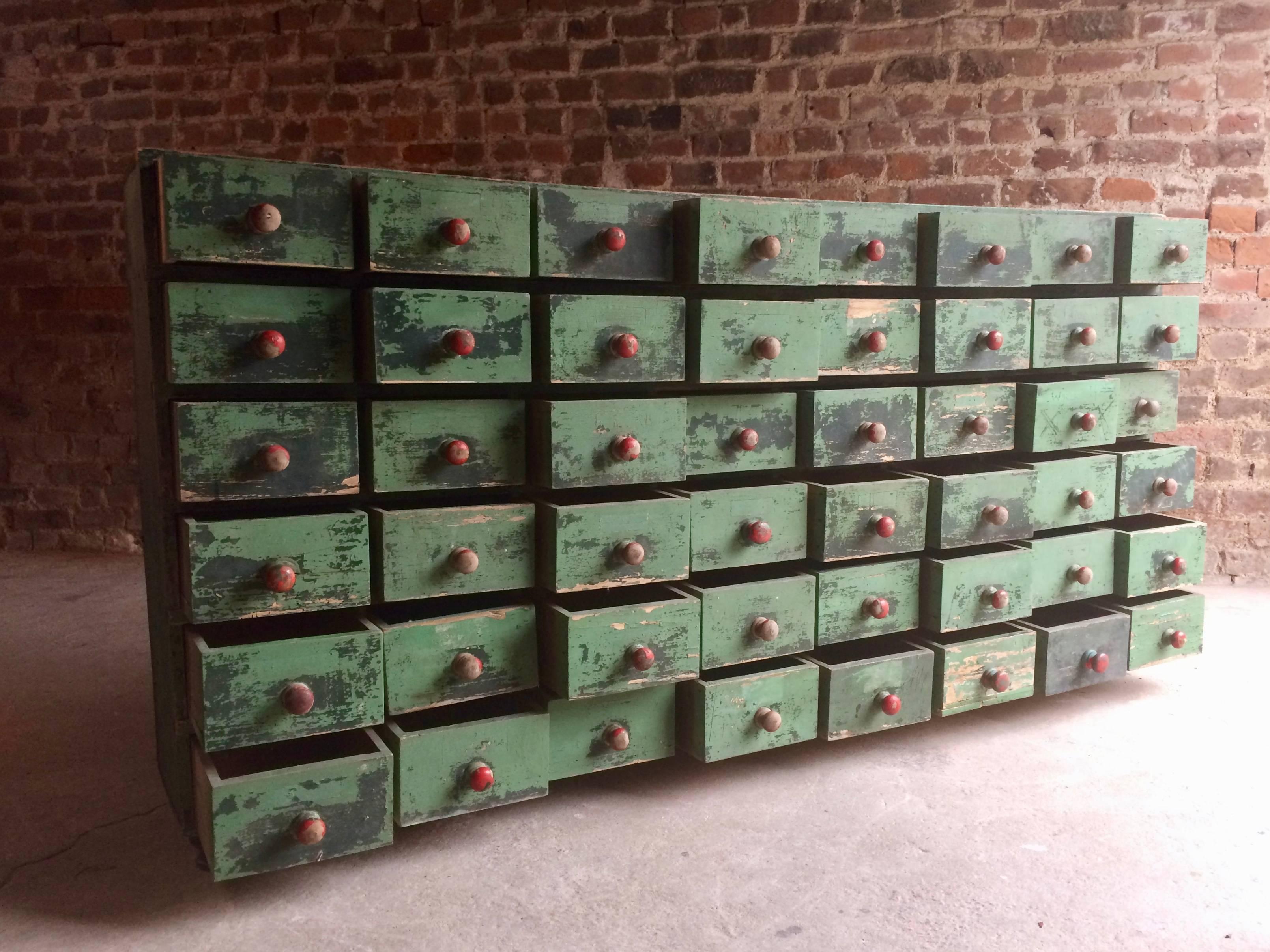 A stunningly beautiful, heavily distressed Haberdashery 'Seed Merchants' pine bank of forty eight drawers, circa 1930s, seriously distressed green paintwork throughout, forty eight small drawers all with knob handles, raised on four short feet, very