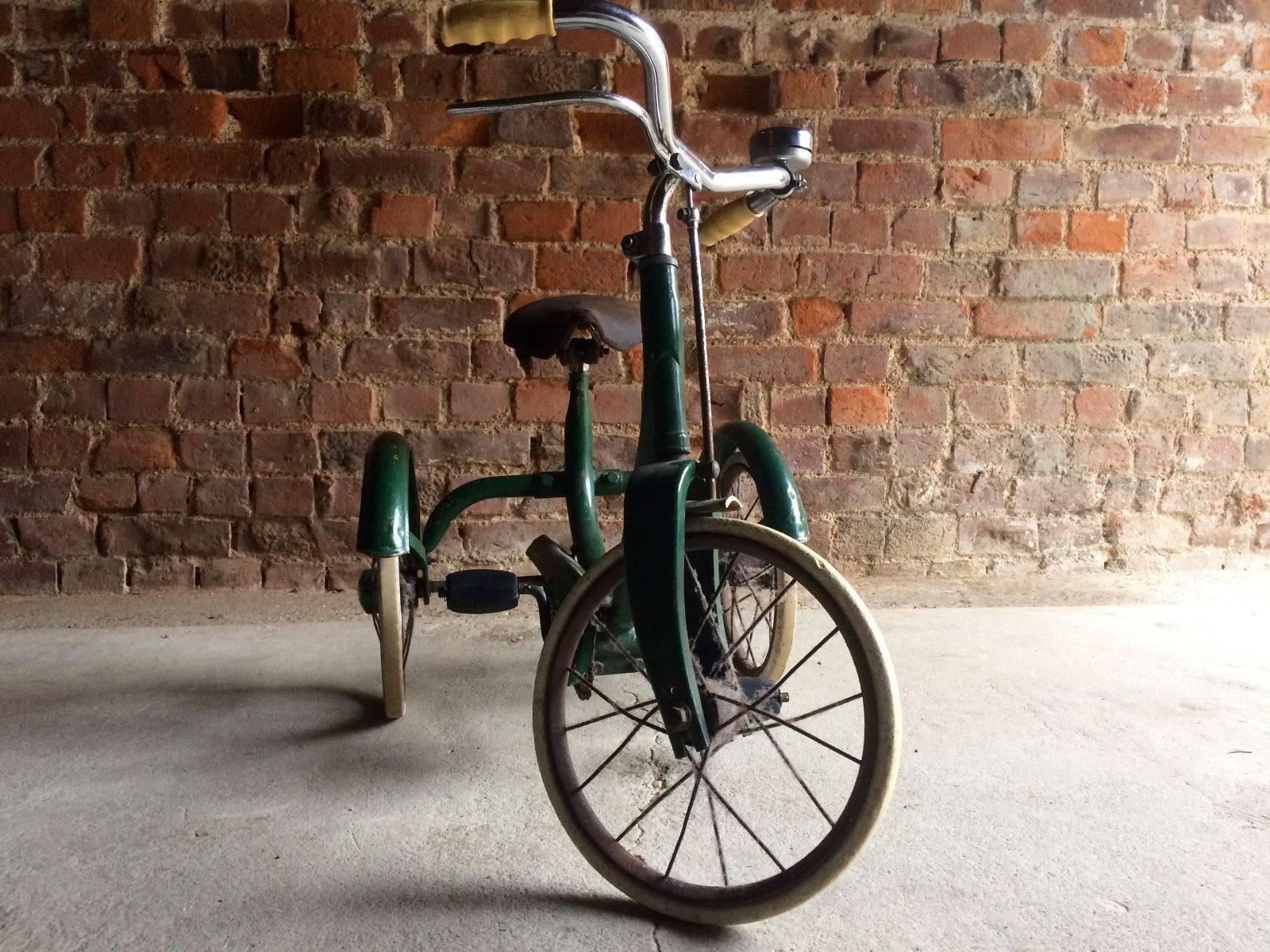 A stunning antique mid century early 1930's tricycle with brown leather saddle, solid 
tyres in working order. Painted in British racing green colour, looks amazing.