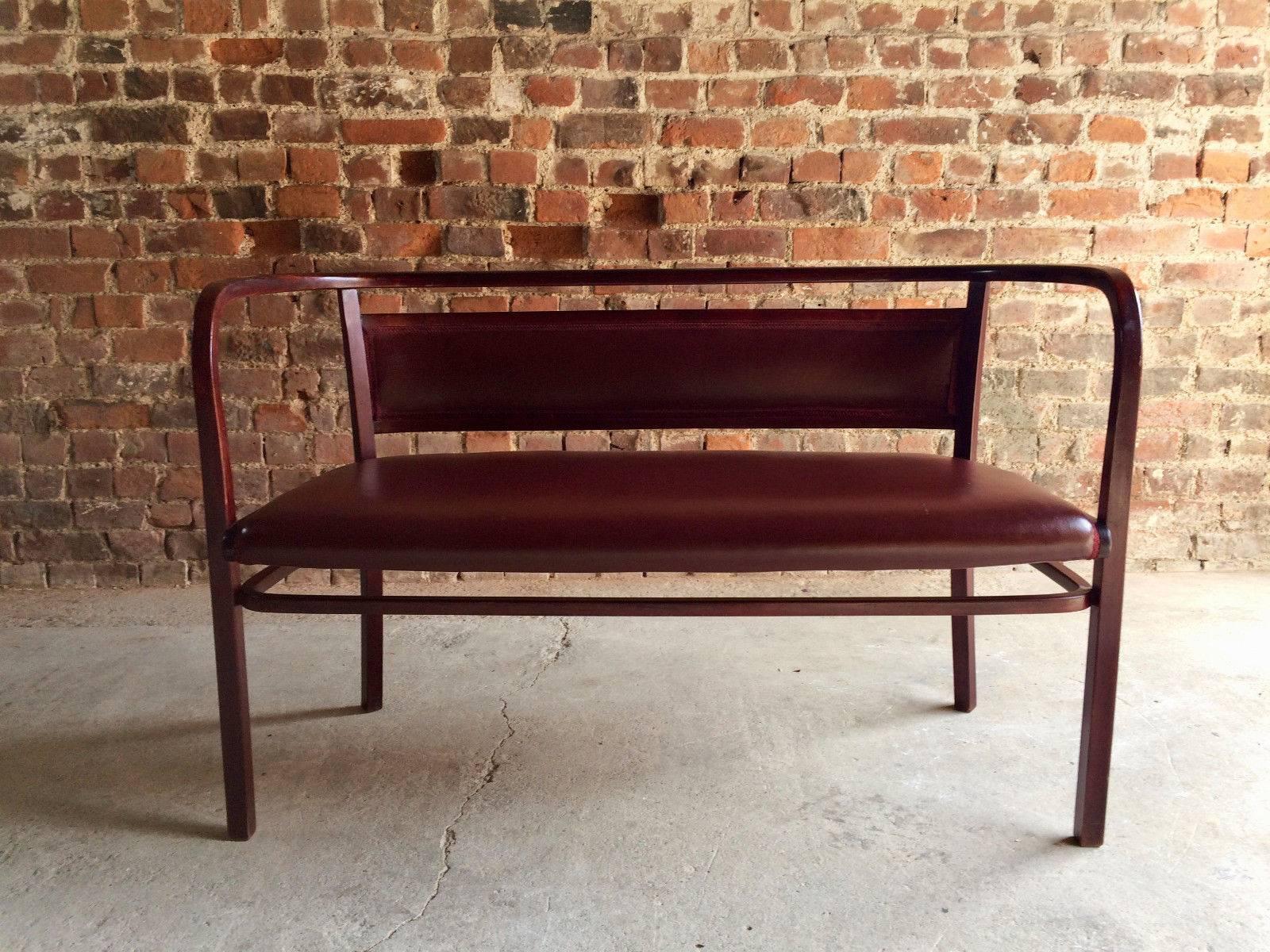 A magnificent Otto Wagner for Thonet stained beech bentwood sofa or bench, designed and dating to 1908, upholstered in burgundy vinyl with matching braiding, makers mark and branded to underside - 'Thonet 3' with applied label in Cyrillic script,