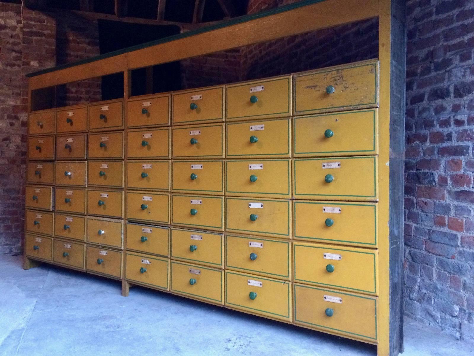A stunningly beautiful early 20th century pine yellow and green French painted 'Seed
Merchants' haberdashery cabinet, with a total of 42 drawers, all with green knob
handles and original captain's labels. The haberdashery standing on four block