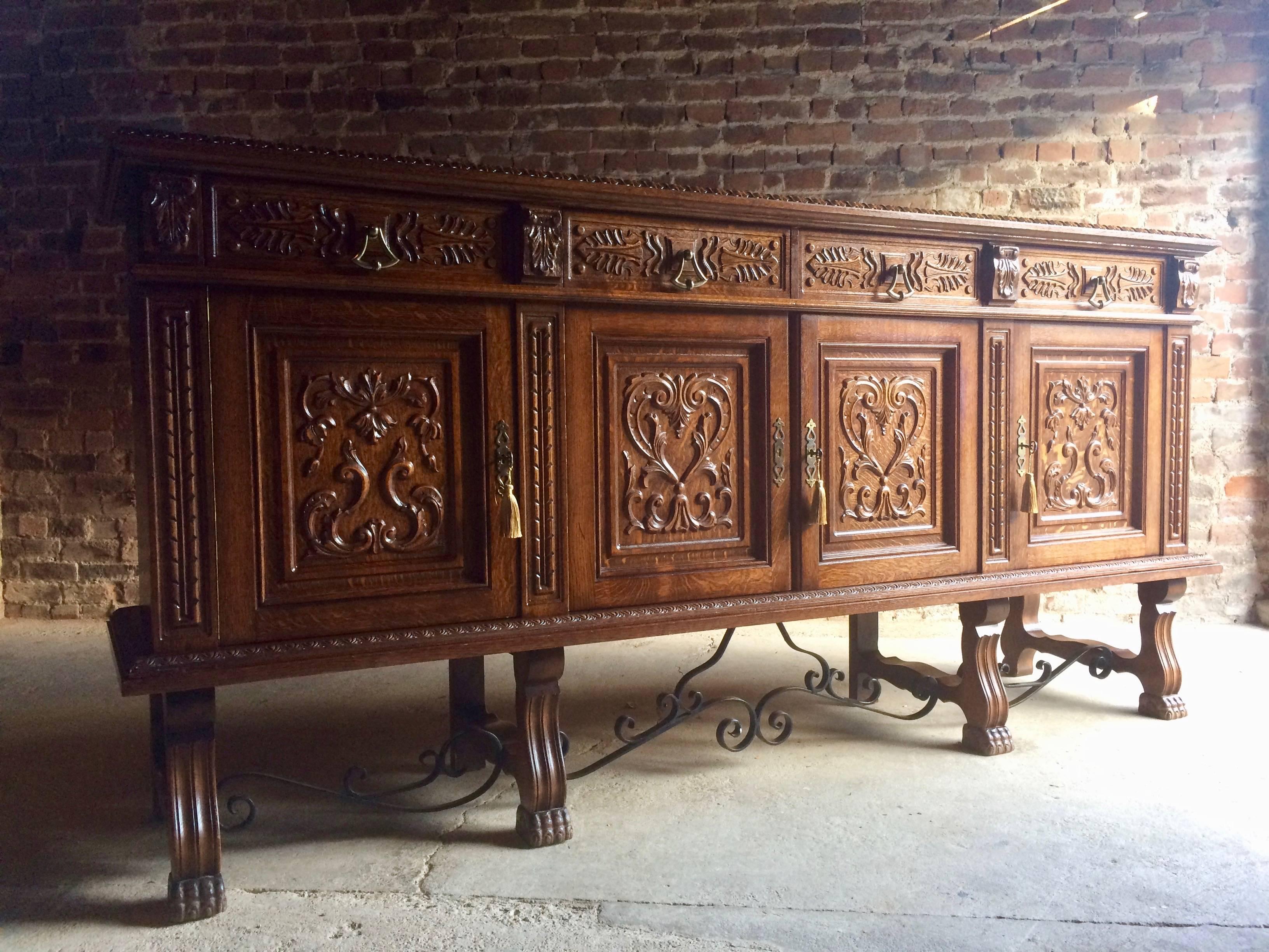 A beautiful statement piece, extremely large and imposing antique style French heavily carved oak sideboard credenza, the long rectangular oak top over four carved cushion drawers, over four heavily carved panelled doors, with three working keys and