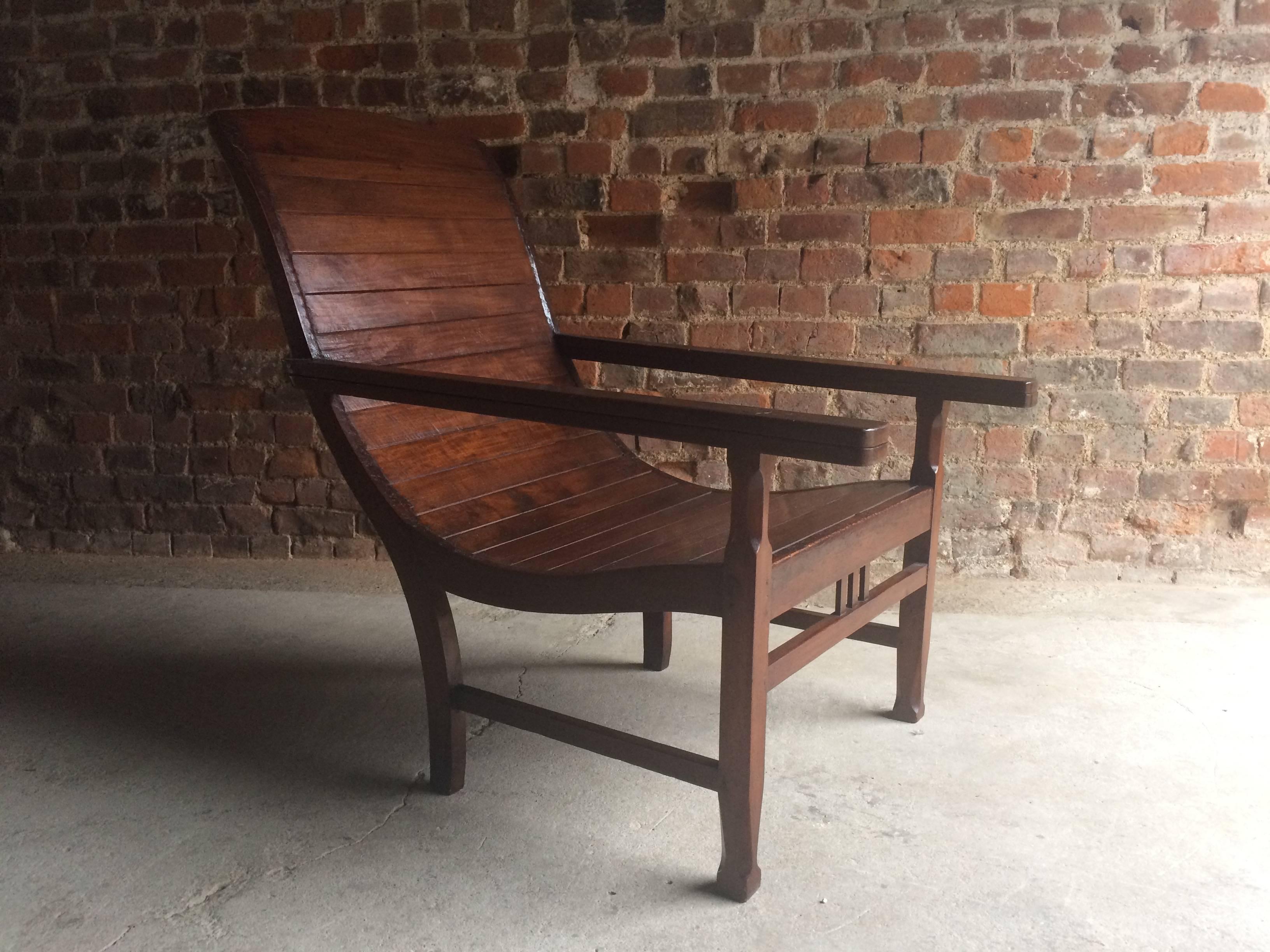 A magnificent early 20th century antique Tea Planters or Plantation hardwood armchair with Dutch coins inset to arms dated 1920, the chair has fully extending arms (used originally to dry the farmers boots), wonderful clean lines and extremely