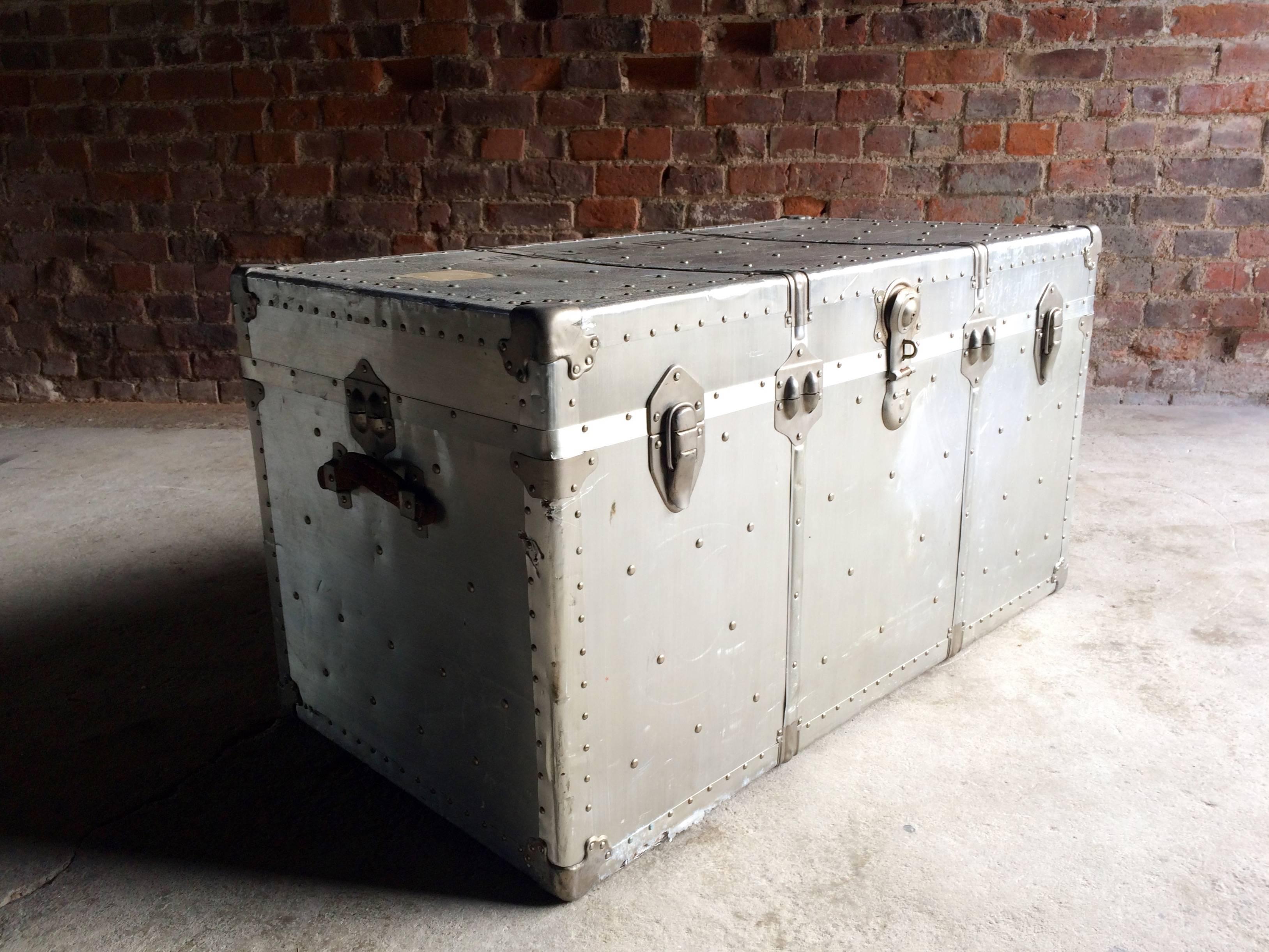 A stunning and original, vintage Industrial zinc aviation travelling streamer trunk with hinged lid. The trunk having 
studded outline and heavy locks, leather carry straps to both sides, riveted all-over, lined fabric with a removable tray