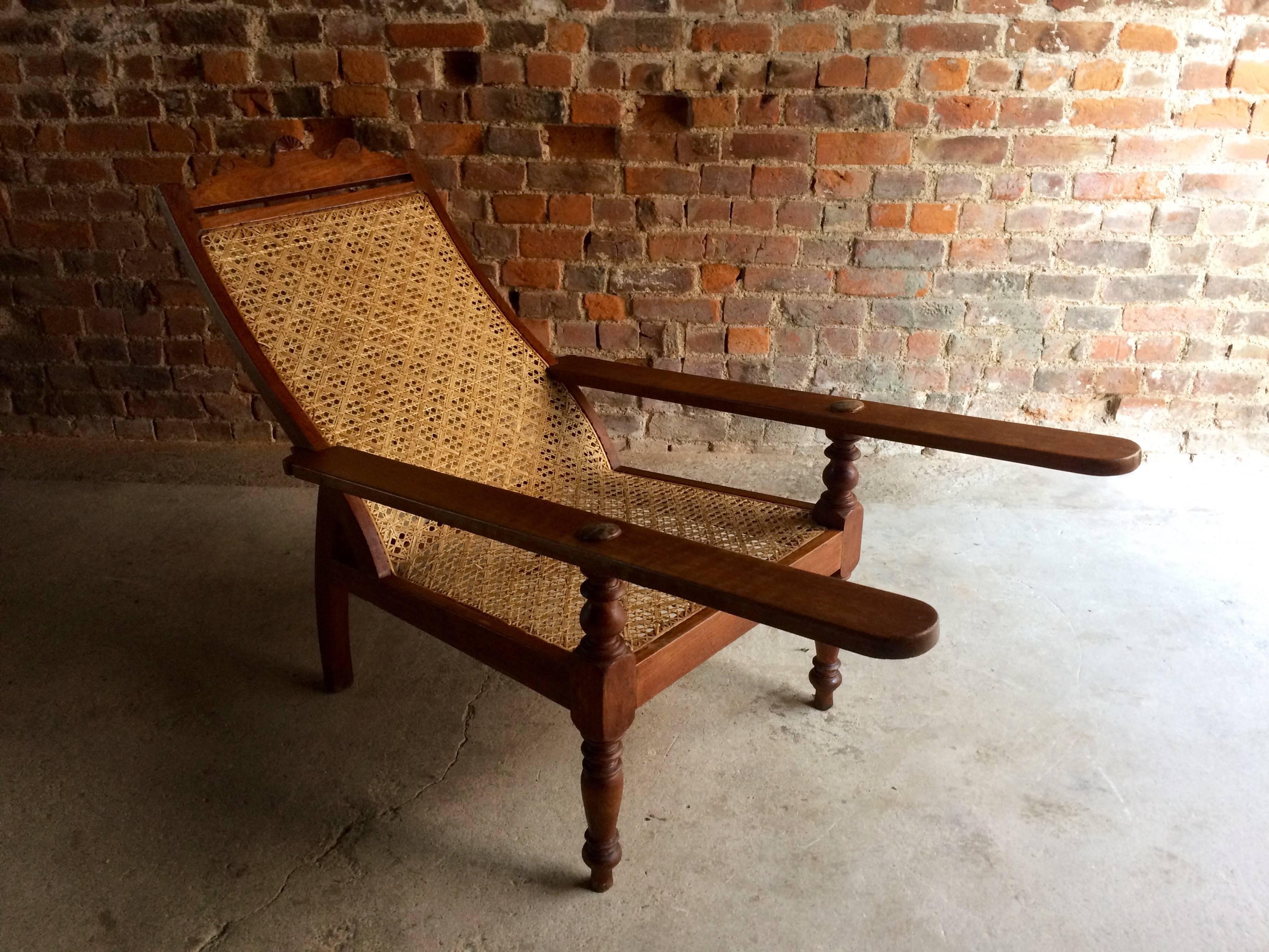 A beautiful and comfortably contoured antique Mahogany ‘Planters’ plantation chair with permanently extending arm/leg rests, 
caning to seat in a geometrical basket weave and in pristine condition, sumptuous lines, sitting on gorgeous arched 
back