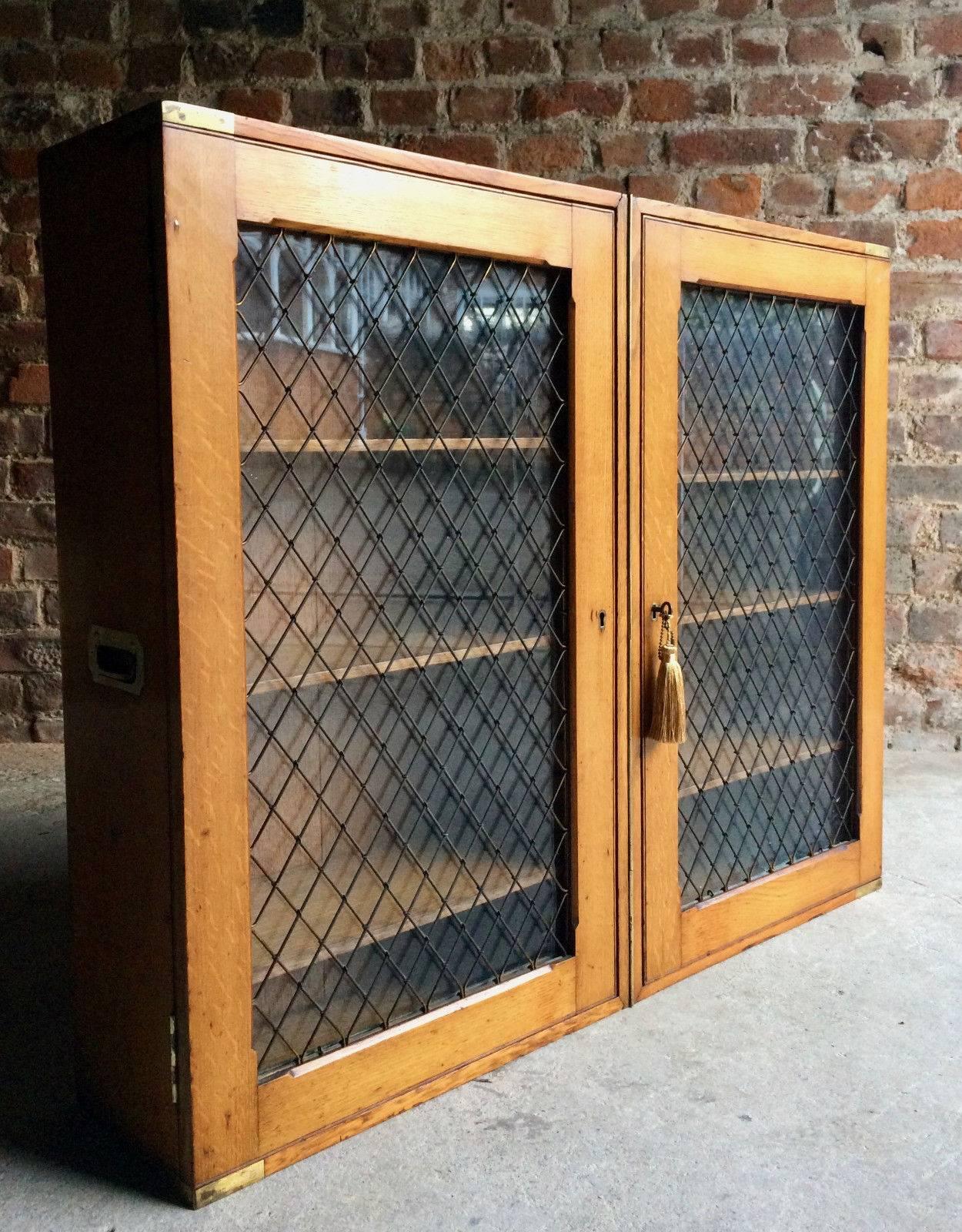 Extremely rare early 19th century military Campaign oak bookcase fitted with two glass and wire mesh doors enclosing six shelves both doors with original working locks, brass bound with carry handles to sides, comes with one original working key