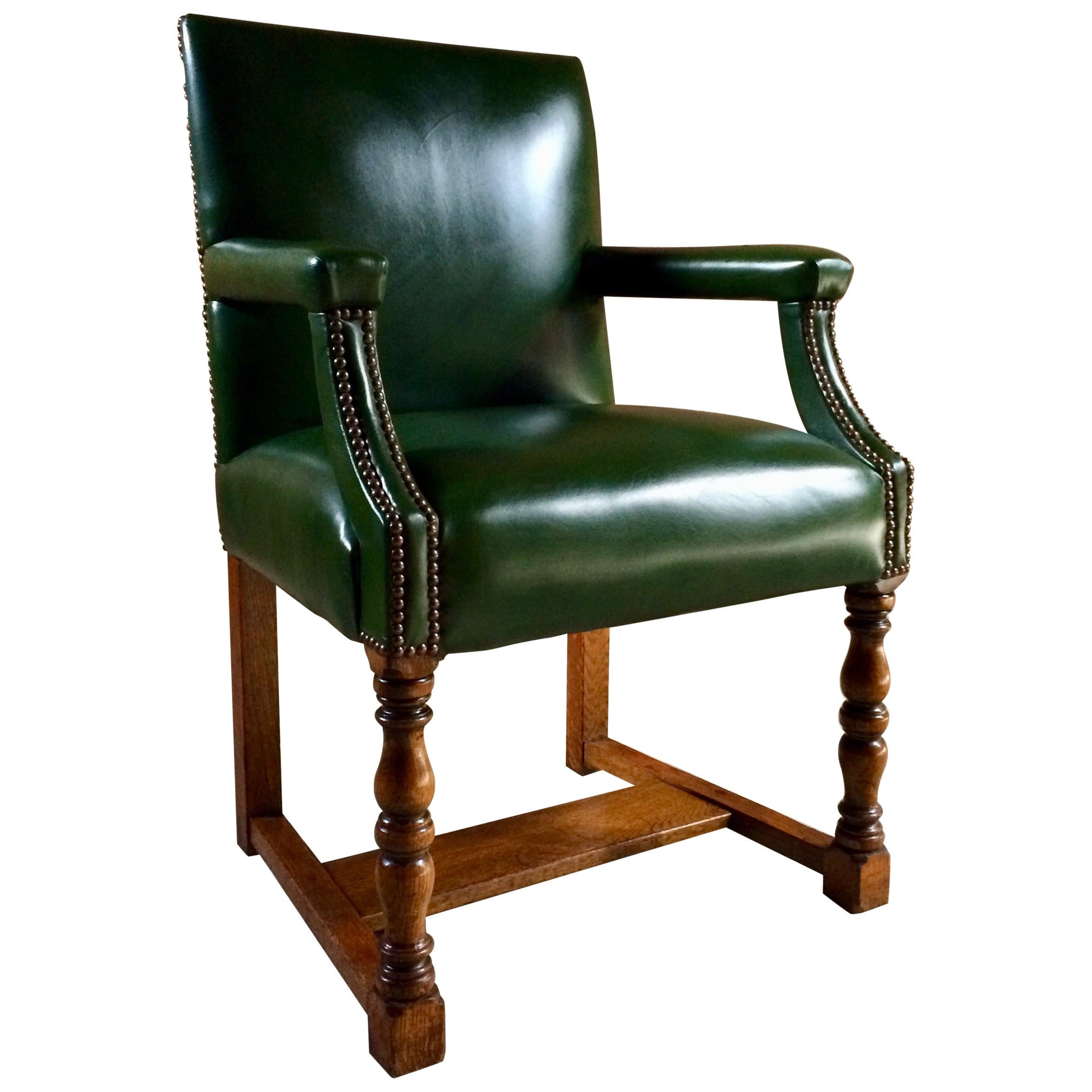 Howard & Sons solid oak Gainsborough library or boardroom chairs dating to circa 1890, the chairs have recently been re upholstered in the finest deep bottle green leather with brass stud bound work, raised on turned legs, joined by H stretcher,