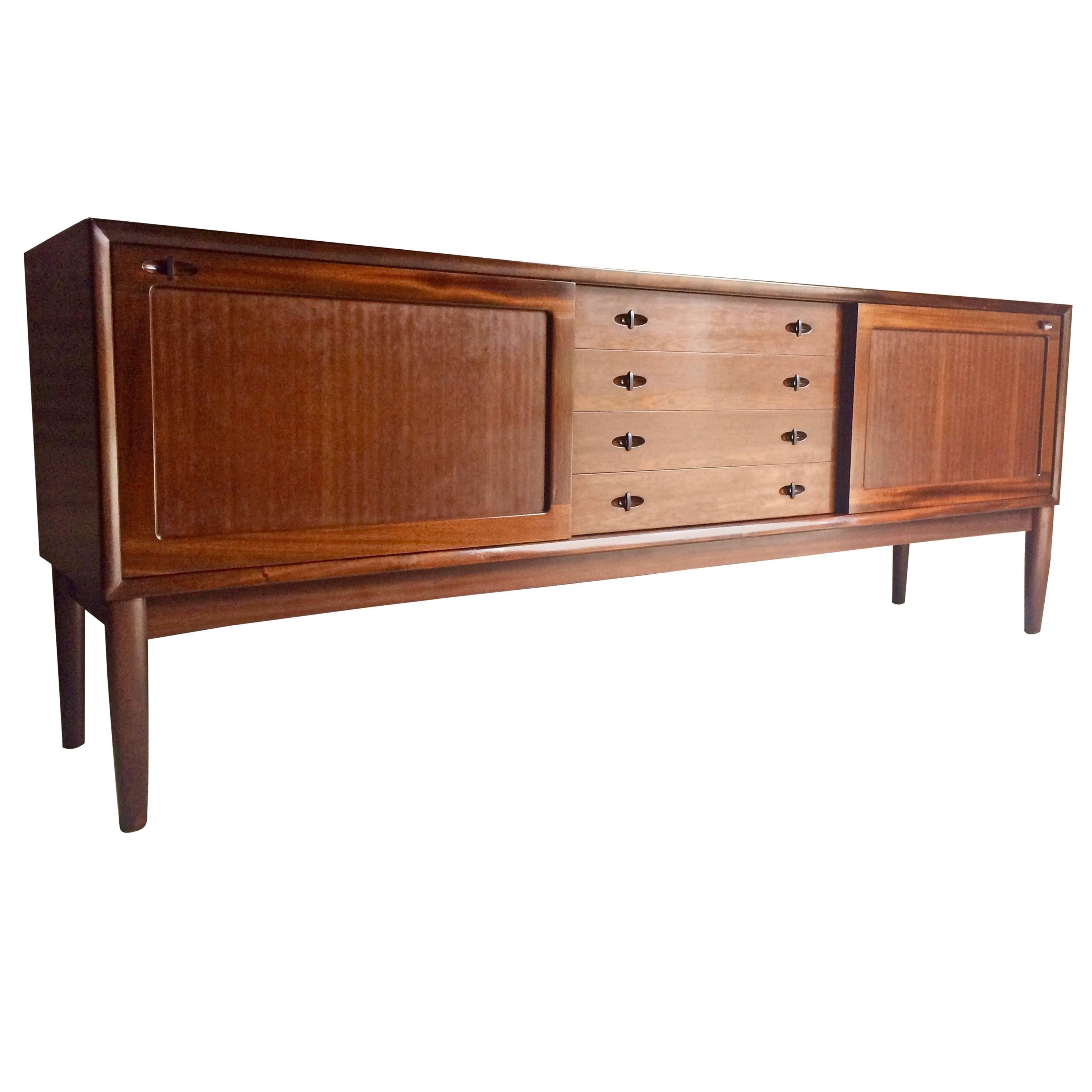 Magnificent Classic Danish modern midcentury solid dark teak sideboard credenza designed by H.W. Klein and manufactured by Bramin, the rectangular top over two large sliding doors with adjustable interior shelving, flanking a flight of four central