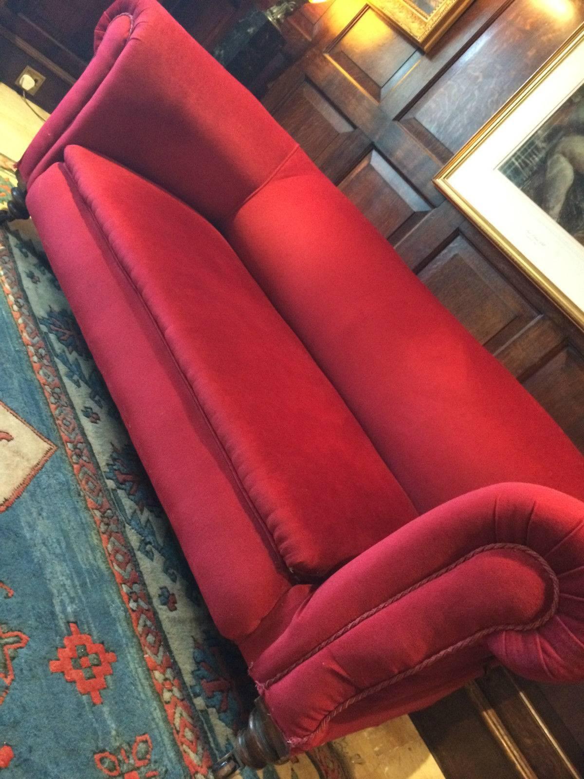 A beautiful antique Victorian Chesterfield three-seat sofa recently reupholstered in lush 'Scarlet Red' velvet material, the sofa has a lever to the right allowing the right arm to drop at adjustable heights, offered in excellent condition, sitting