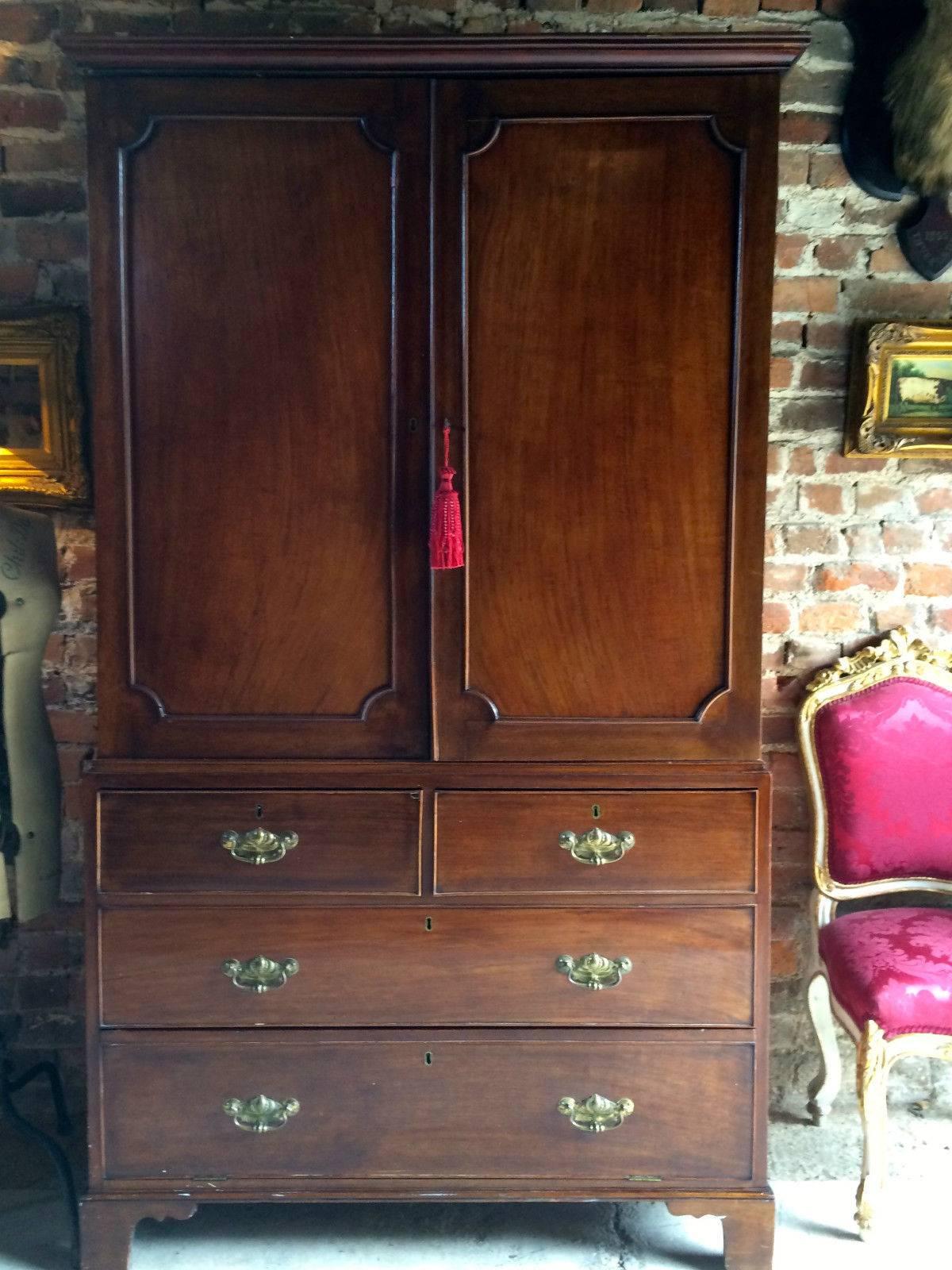 A 19th century Victorian Mahogany linen press over chest, stepped pediment over a pair of fielded panel doors with moulding, enclosing three adjustable slide shelves, above two short drawers and one long dummy drawer over a double height drop down