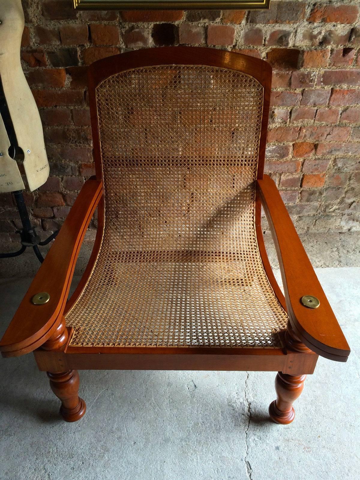 A contoured antique style ‘Planters’ plantation chair with permanently extending arm/leg rests, caning to seat in a geometrical basket weave and in pristine condition, sumptuous reclining lines, sitting on gorgeous arched back legs with turned front