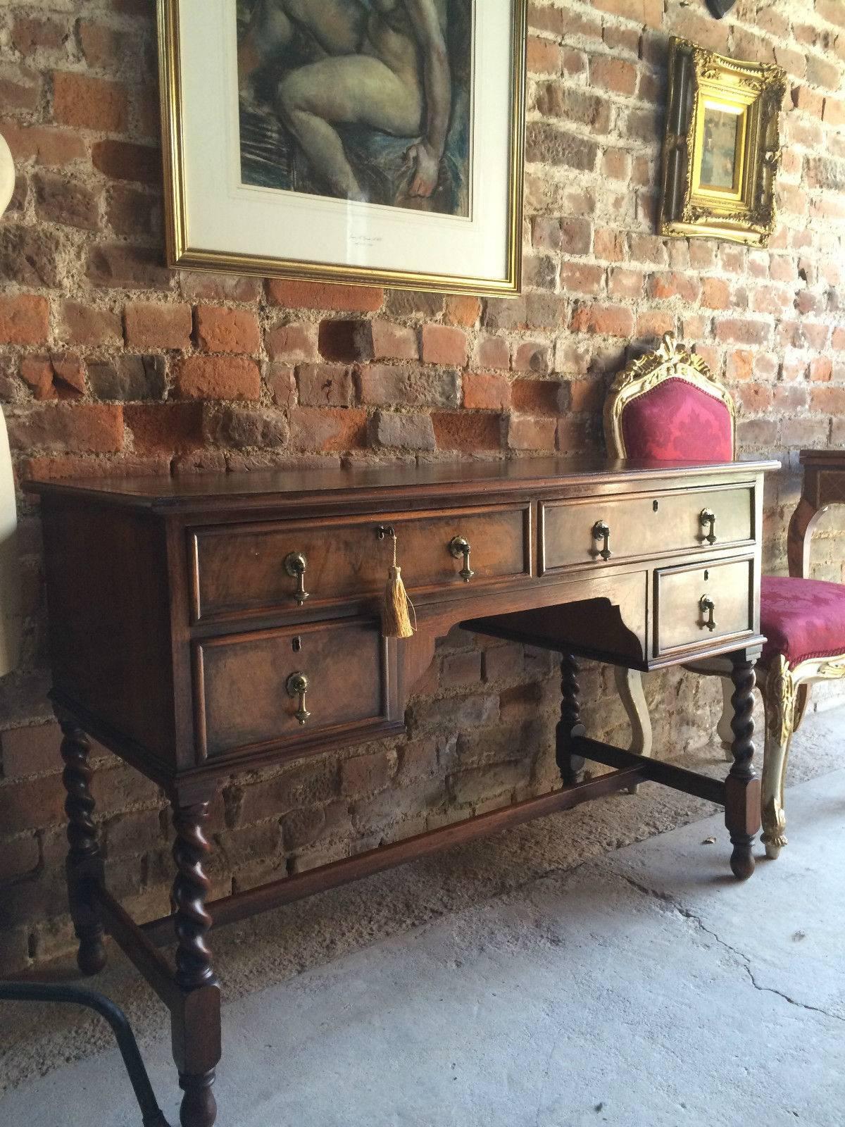 Antique style walnut writing table desk with green and gold tooled leather inset, the desk having two short and two drawers all with brass drop handles with shaped apron, standing on four barley twist legs united with H-stretcher, comes with one