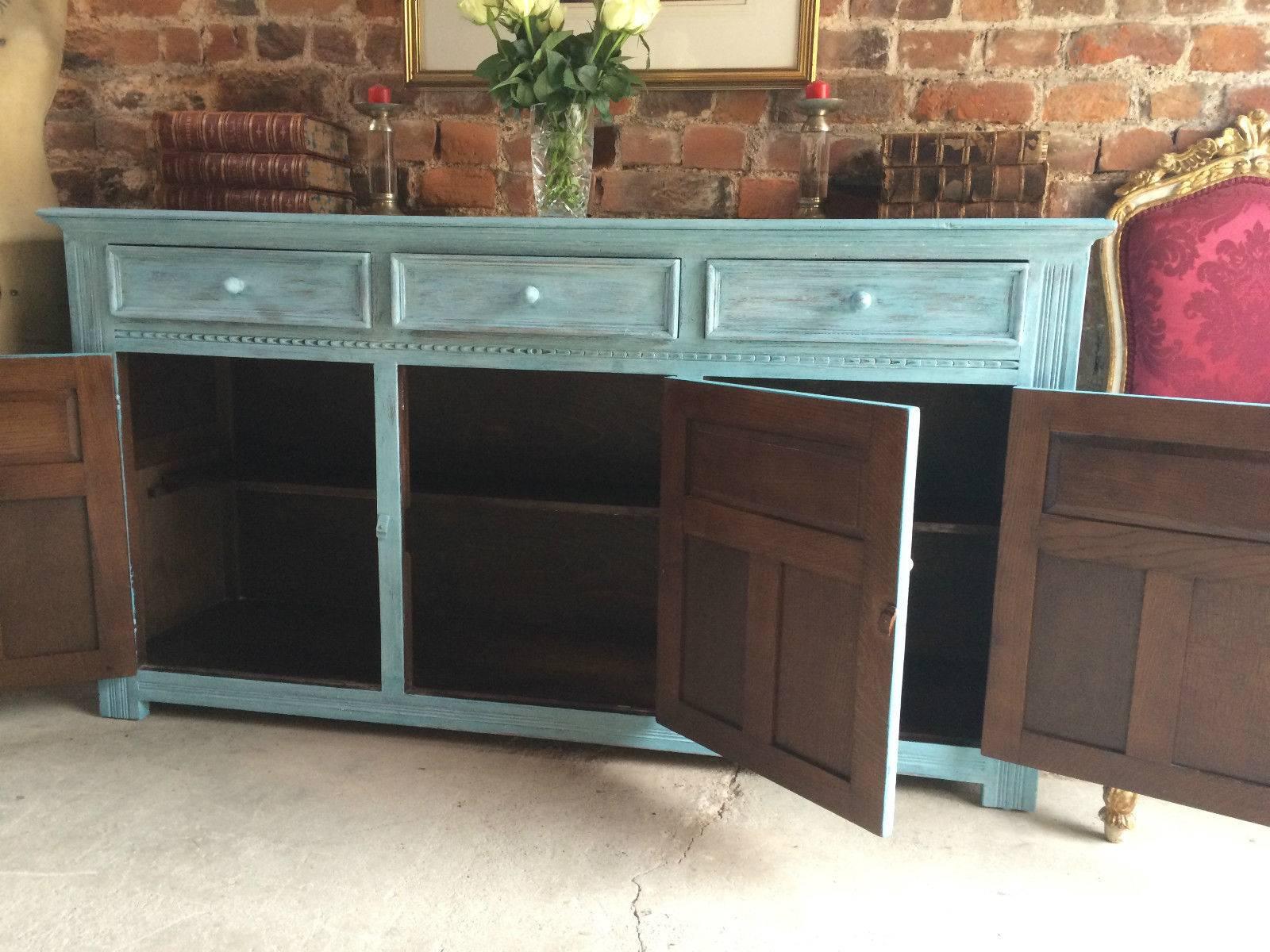 A ‘Beach House Chic' sideboard, rectangular top over three frieze drawers, over three cupboards with carved paneled doors all with acorn knob handles, finished in ’Teal’ white waxed and seriously distressed, please note this is a moderately heavy