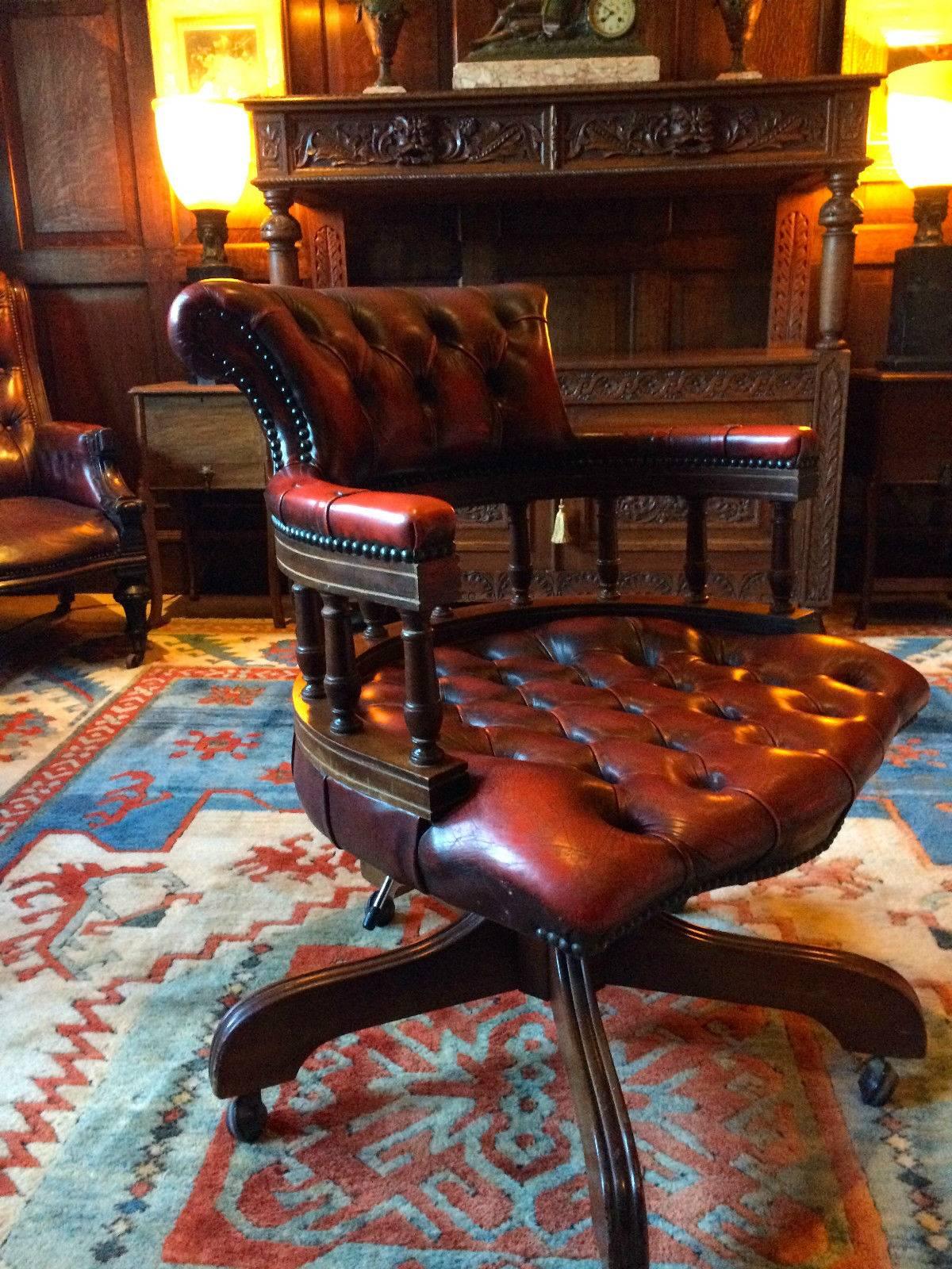 Gorgeous antique style reclining and revolving chesterfield 'Captains Chair’ leather button-back Ox blood leather, with overstuffed back and arms, spindle railed back and overstuffed seat, raised on four turned legs terminating in casters.