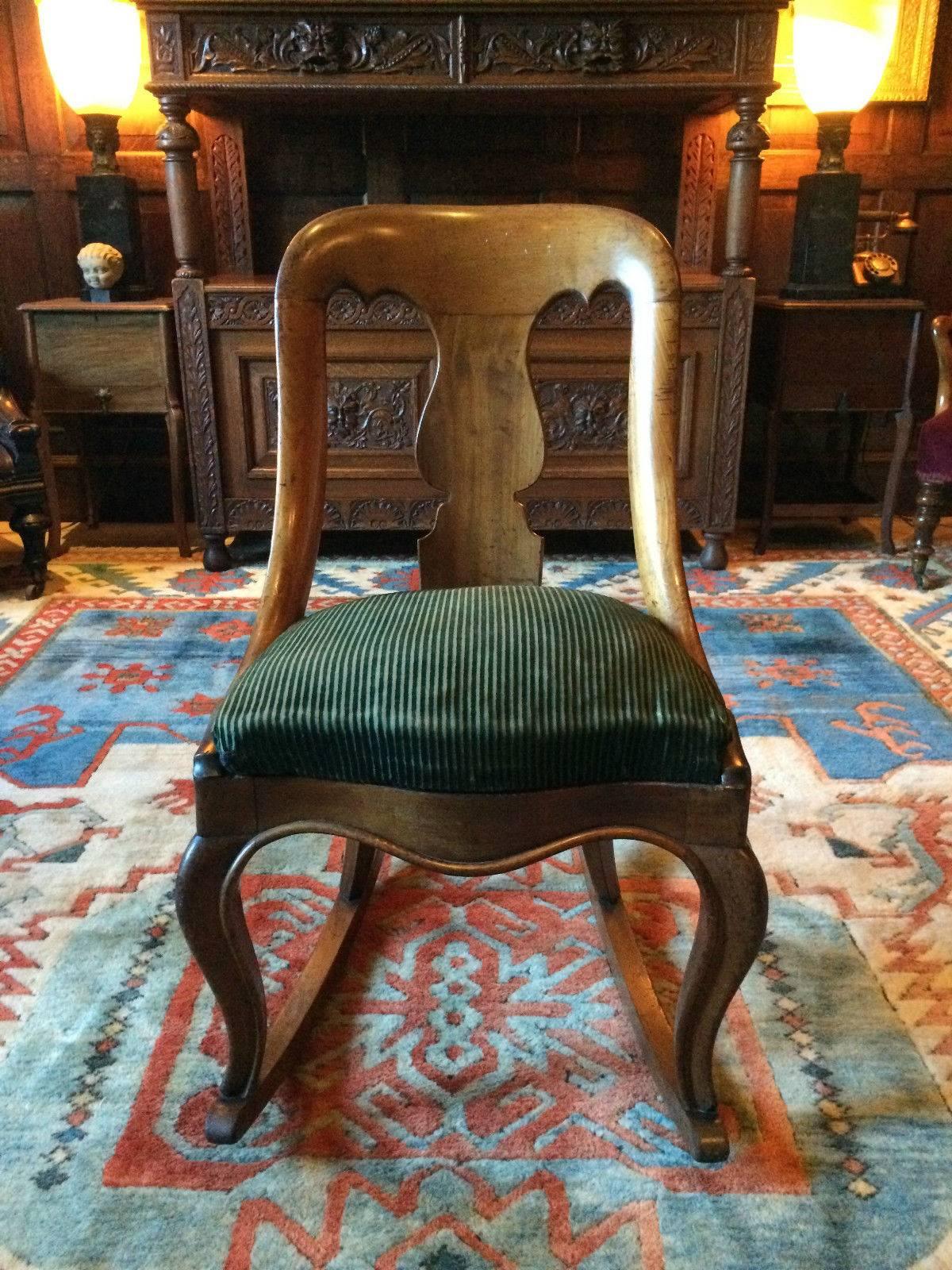 A stunningly beautiful and very rare antique early Victorian light mahogany rocking chair circa 1840, with curved Gothic style back support and overstuffed seat that has been re webbed and stuffed, standing on turned cabriole front legs resting on
