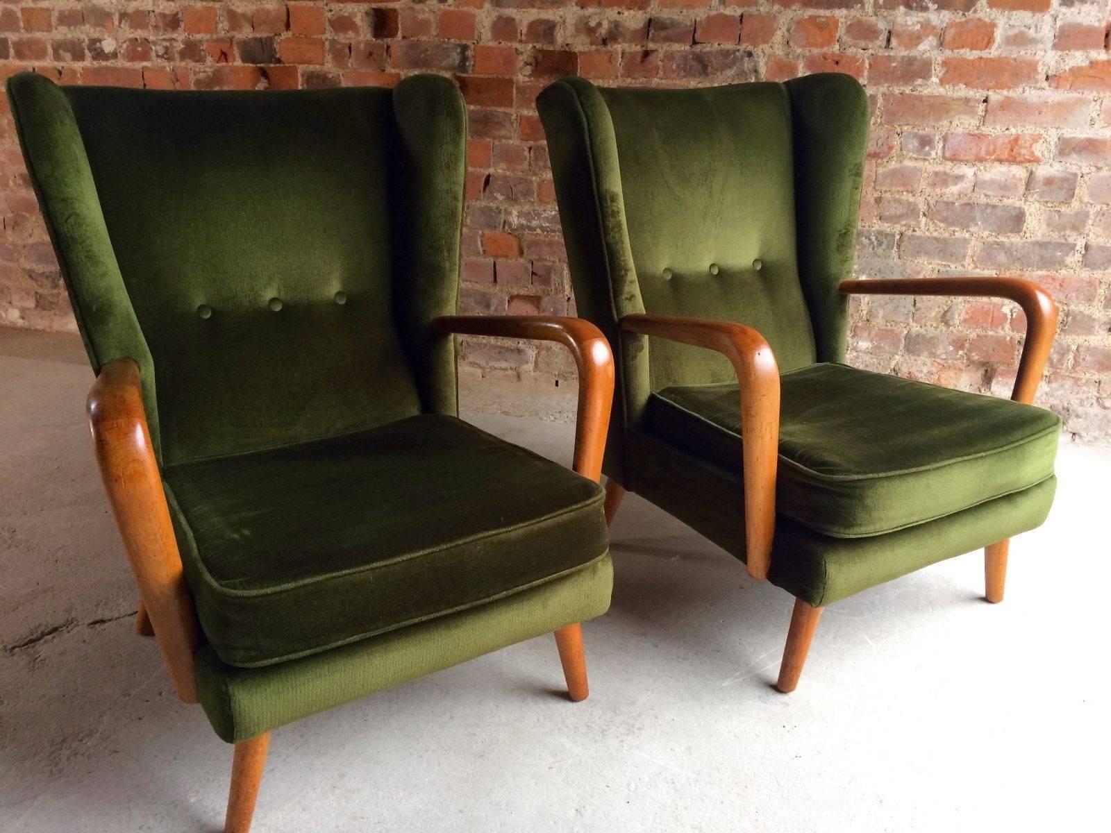 A stunningly beautiful and original pair of Howard Keith 'Bambino' armchairs offered in mint original condition and untouched circa 1960s, the chairs are offered in original condition with a deep bottle green velour upholstery, stamped HK to base,