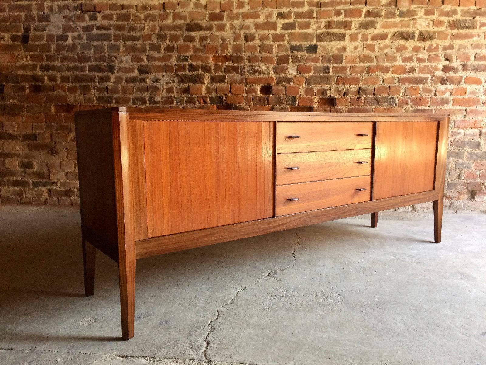 A beautiful Mid-Century Danish design teak sideboard credenza circa 1970s, this elegant sideboard with long rectangular top with canted corners over four central drawers with two tambour fronted cupboards, raised on four tapered legs, this piece is
