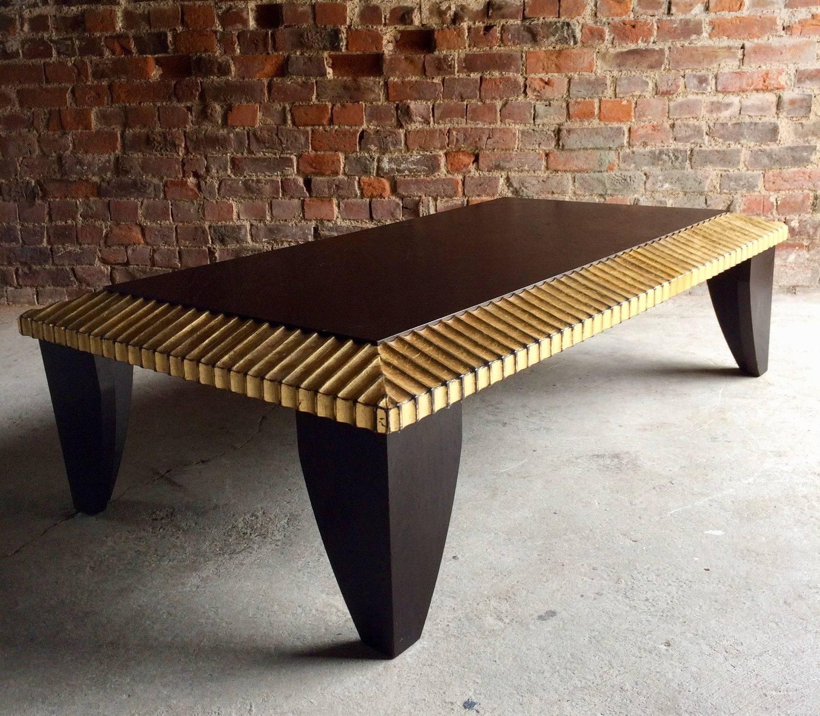 A beautiful contemporary parcel-gilt and ebonised rectangular coffee table or occassional table, with fluted and gilded decoration to the edge and standing on shaped legs, looks amazing.