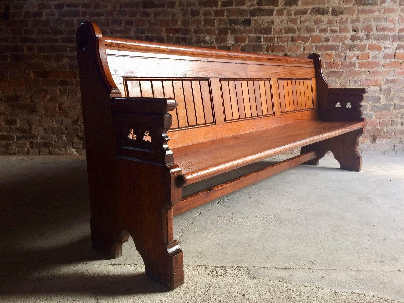 A fabulous large antique 19th century Gothic Revival pitch pine pew, circa 1890, the panelled back and solid seat supported by a pair of pierced and carved trefoil ends.
 