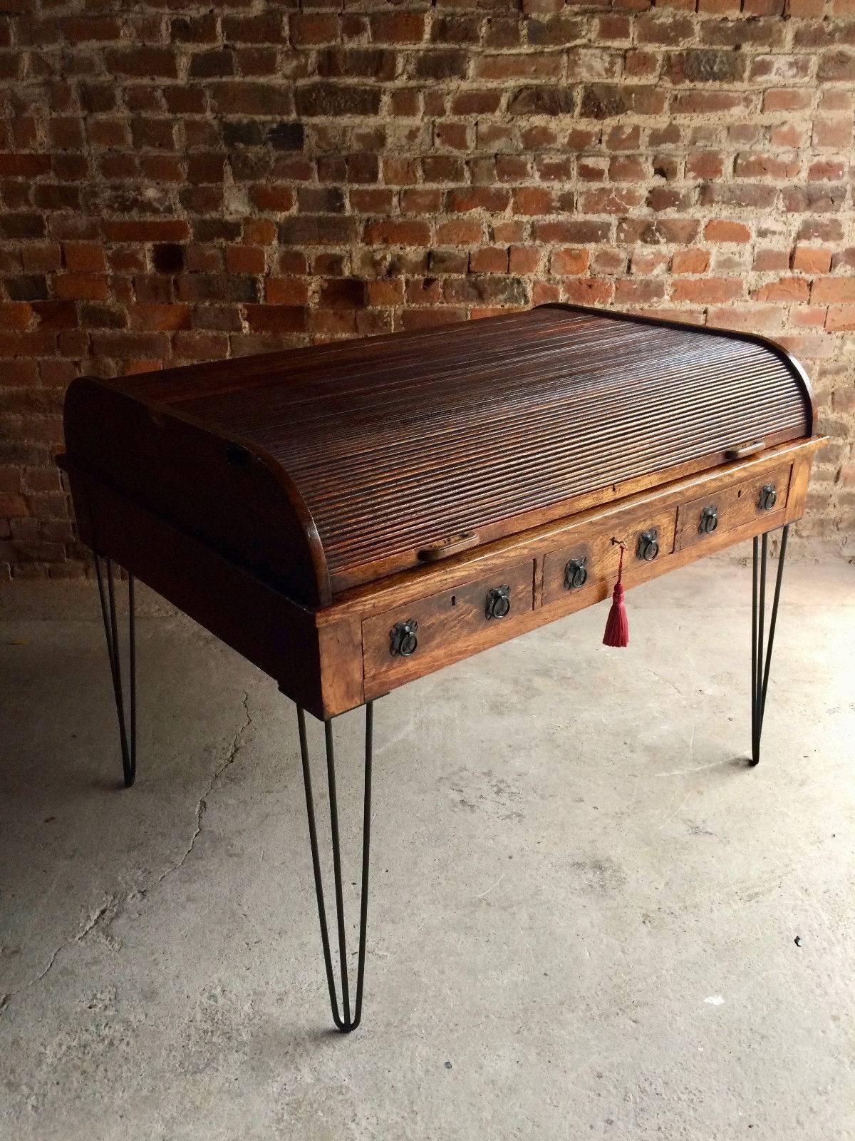 A magnificent antique Edwardian oak roll top desk circa 1903, with tambour slide, above fitted interior and red rexine writing surface, over three frieze drawers on recently added steel hairpin legs, comes with one non working key with tassel, looks