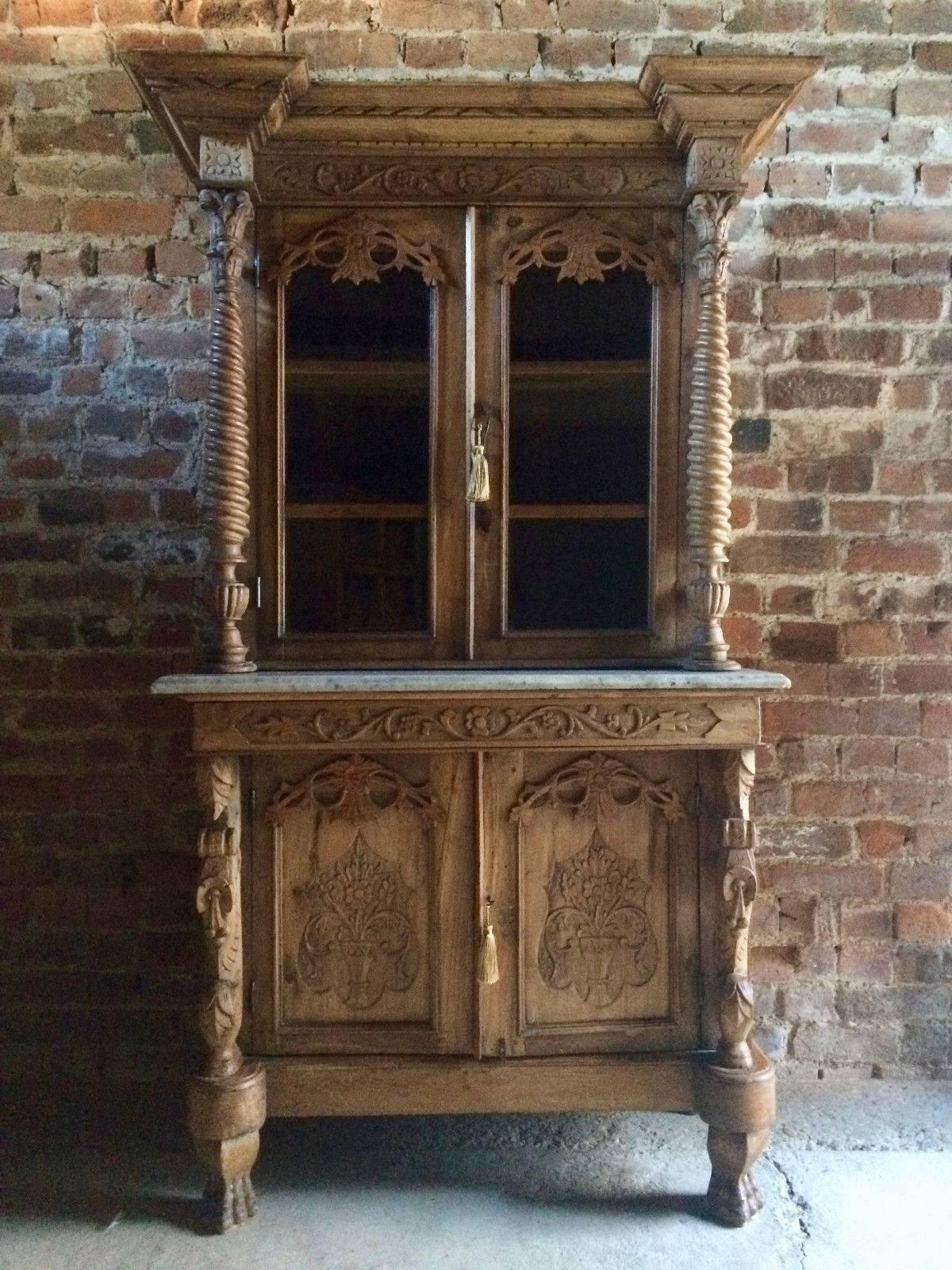 A beautiful antique Anglo-Indian Colonial hardwood display cabinet bookcase, overhanging floral carved frieze above twin glazed doors with floral carved decoration, turned and carved pillar supports to either side, to base with small marble insert
