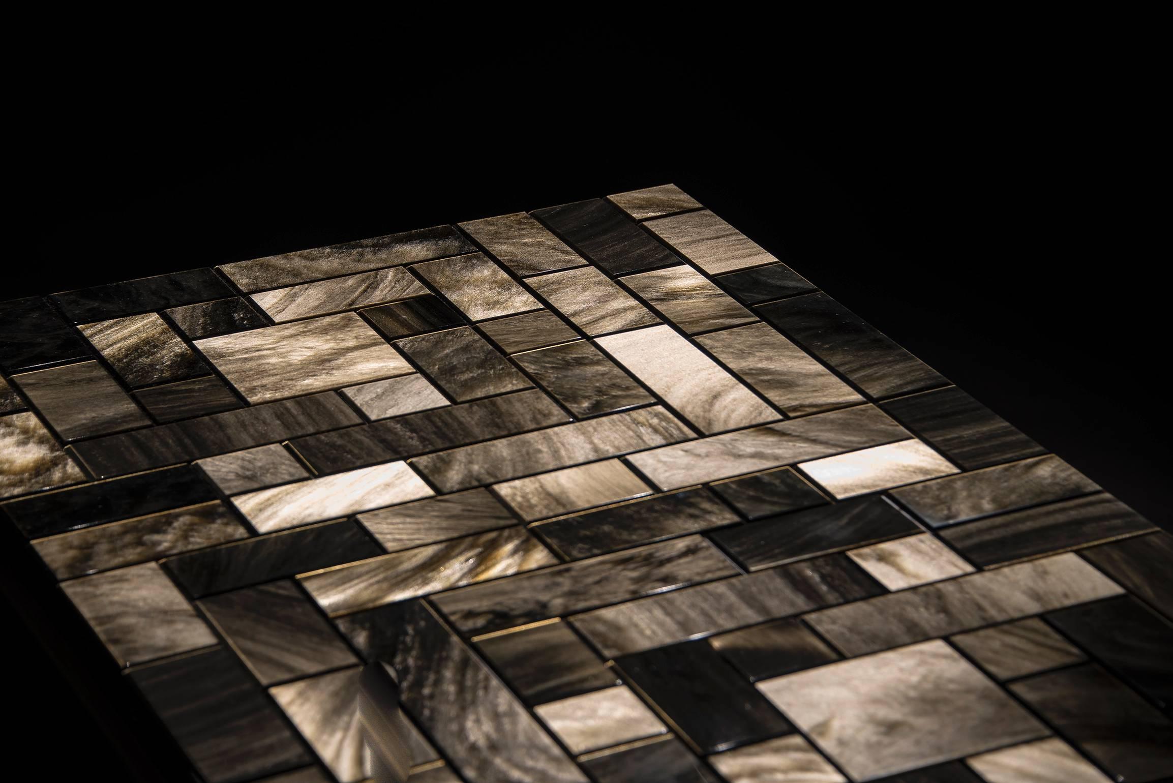 The Golden Universe Table by Gloria Cortina is made of bronze and golden obsidian, the rarest of all obsidians. The table’s simple and sophisticated frame supports a surface of finely cut tiles, arranged in a glittering, reflective pattern of