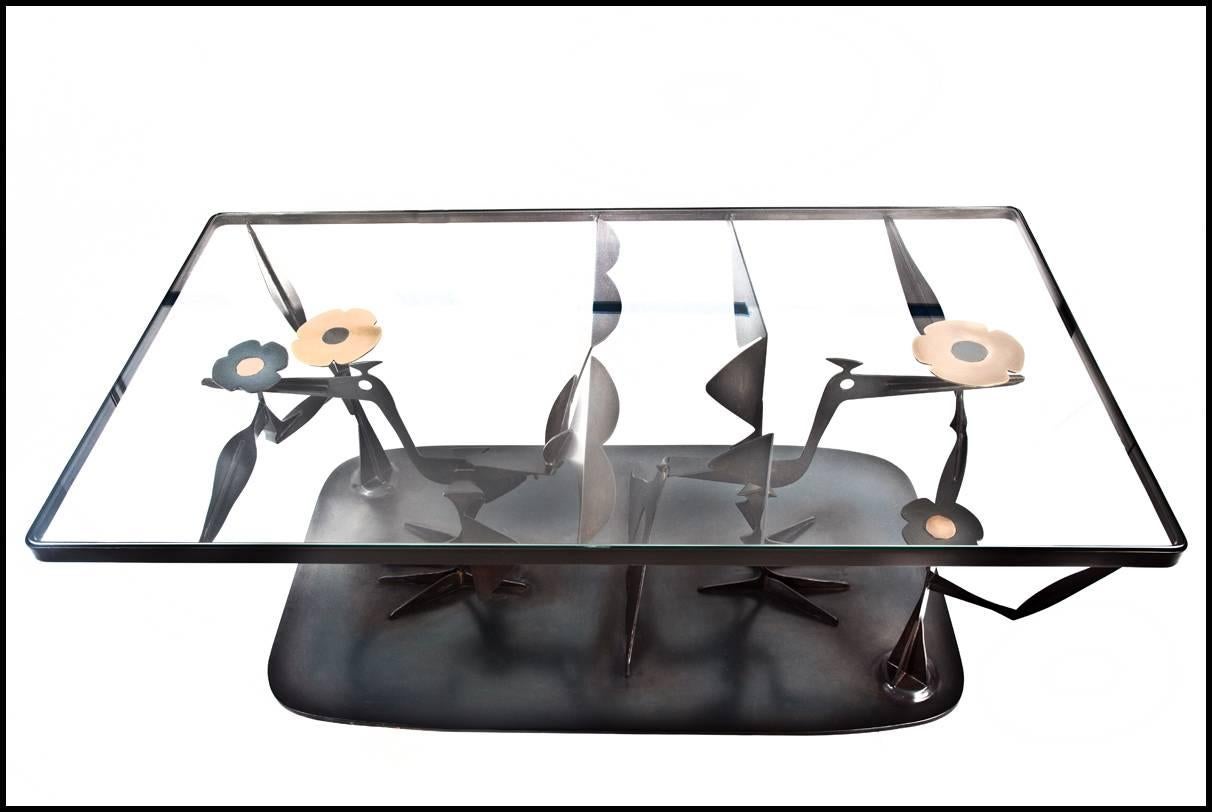 This beautiful coffee table by John-Paul Philippe is made of patinated steel and brass with a glass top. 

John-Paul Philippe is a painter and designer based in New York City, earning his BFA in Art & Art history in 1978 from the University of