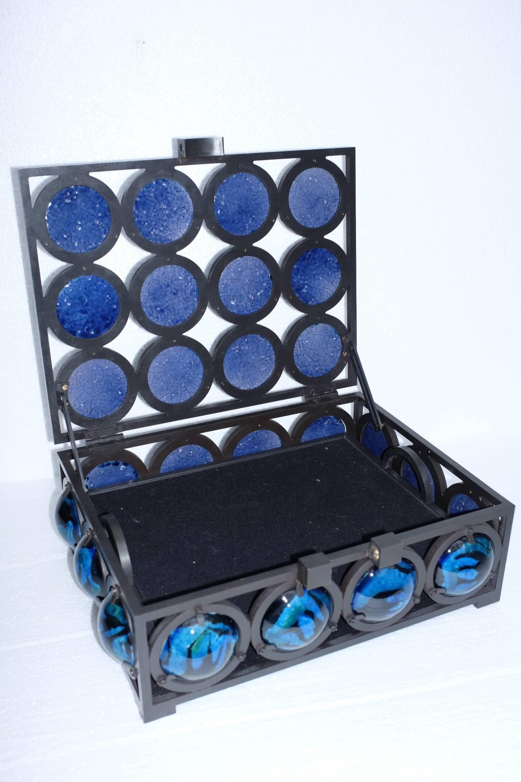 Christophe Côme's blue lava jewel box from 2014 is made of iron and hand-glazed blue lava stone roundels. This jewel box contains one interior removable tray. 

Côme works in Paris, France. Raised in an artistic family, his uncle is a renowned