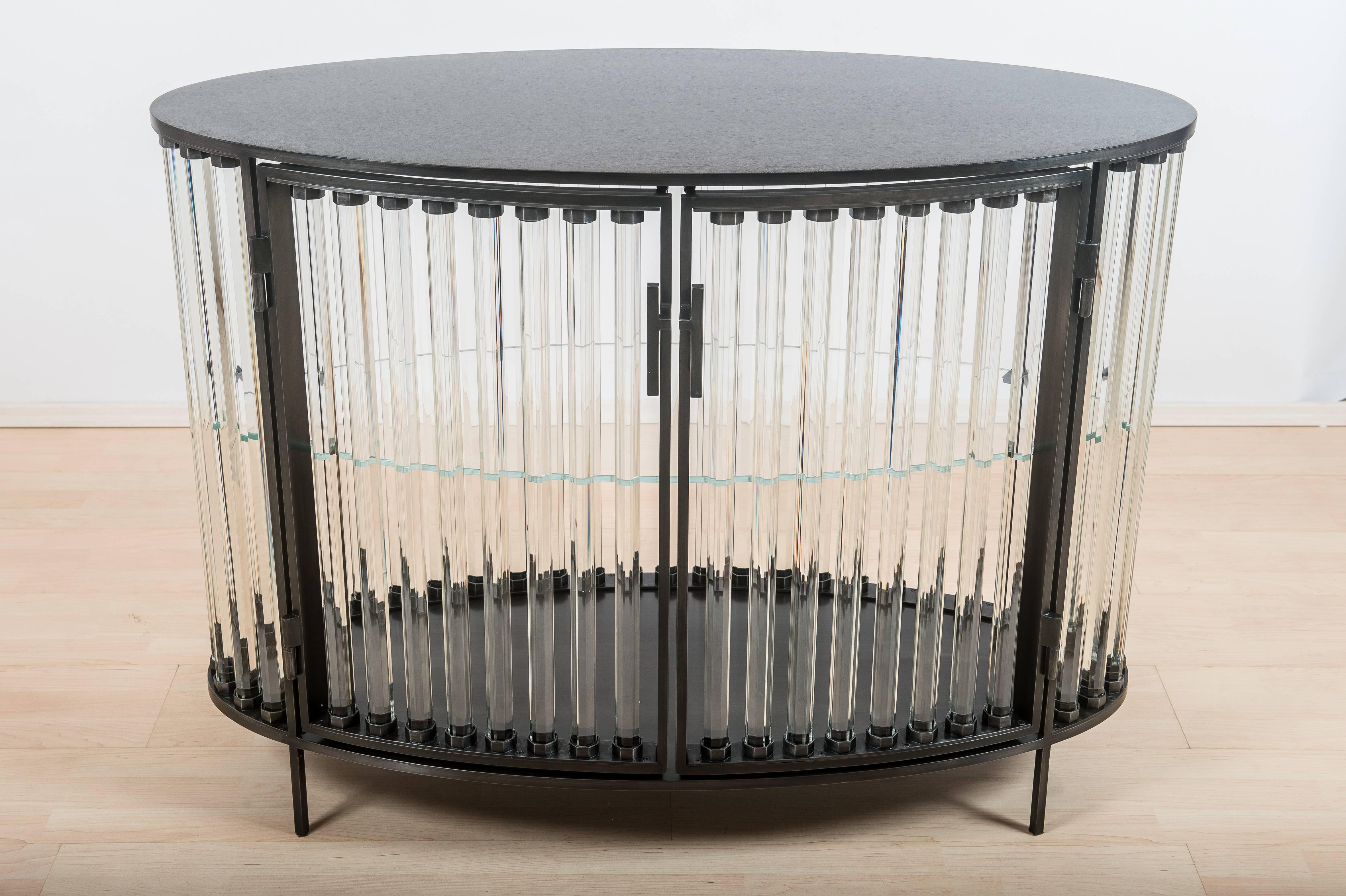 This beautiful cabinet is made of iron and solid glass tubes, and measures 33 7/8” H x 43 3/8” W x 18 ½” D. The oval cabinet is part of Christophe's third solo exhibition at Cristina Grajales Gallery, opening November 2, 2017.

Côme lives and