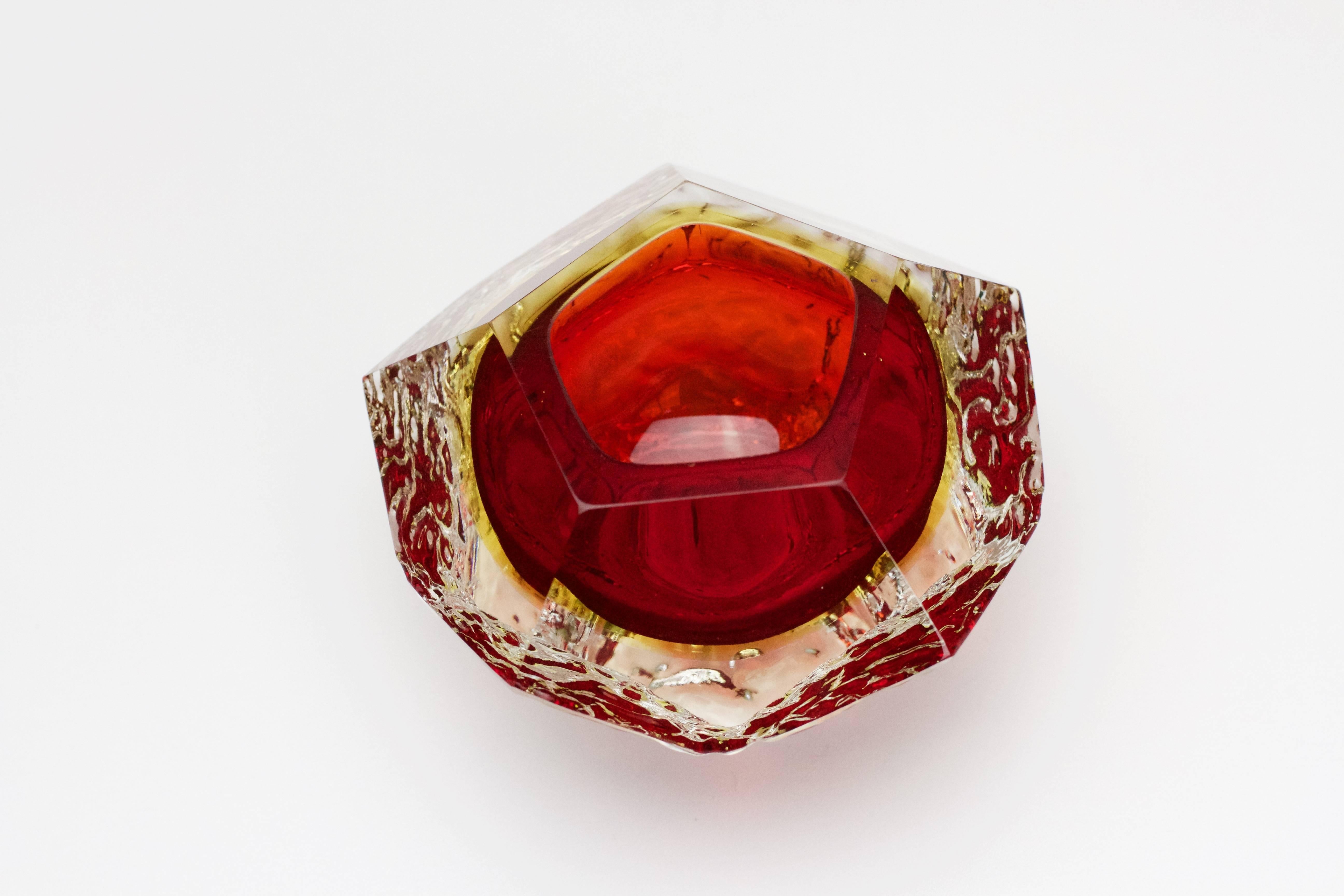 A beautiful little Murano art glass bowl by Mandruzzato, circa 1960. The combination of fire red and the textured clear 'Sommerso' ice glass looks simply stunning.